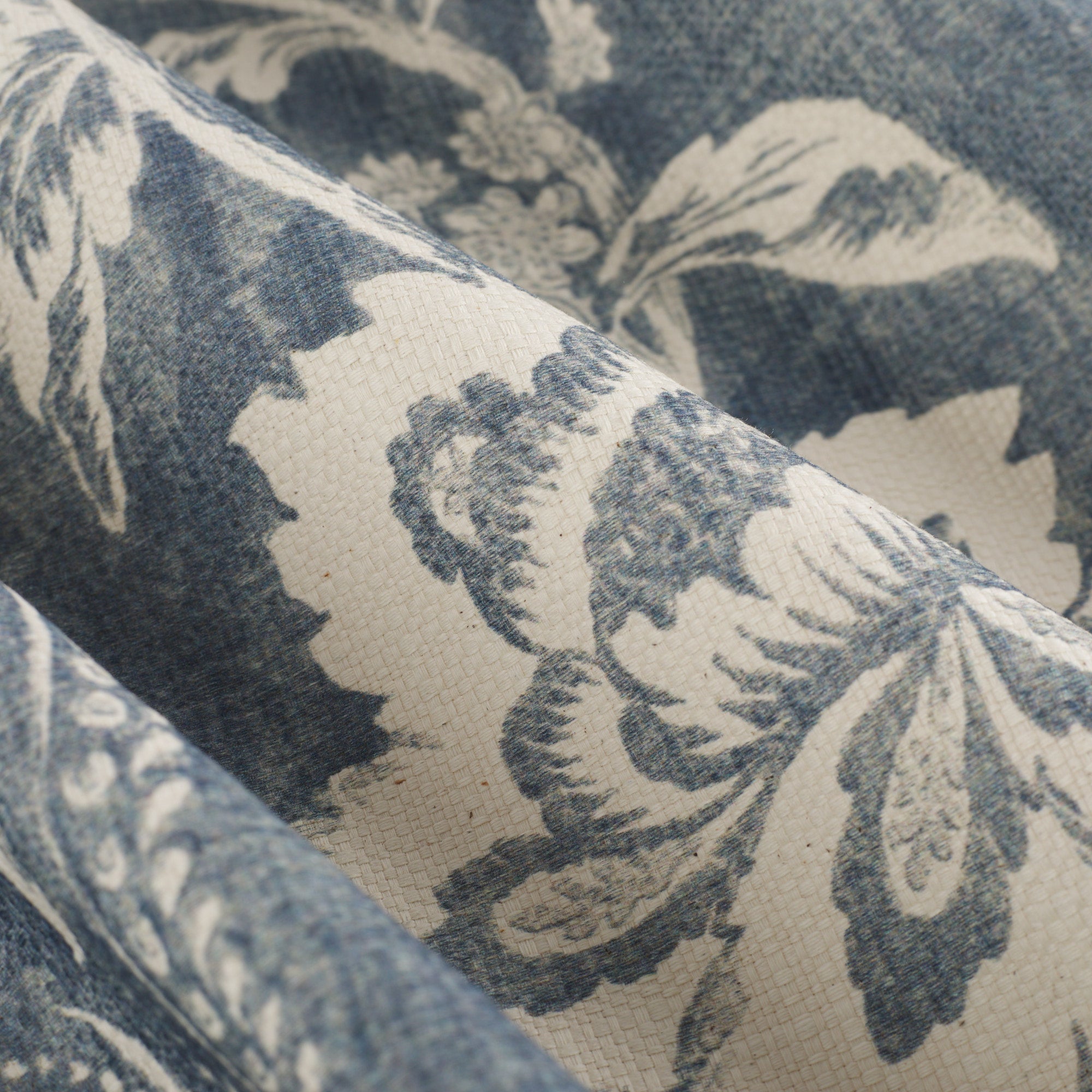 Close up of Tonic Living Ashford Denim fabric showing blue and white scrolling floral vine pattern.