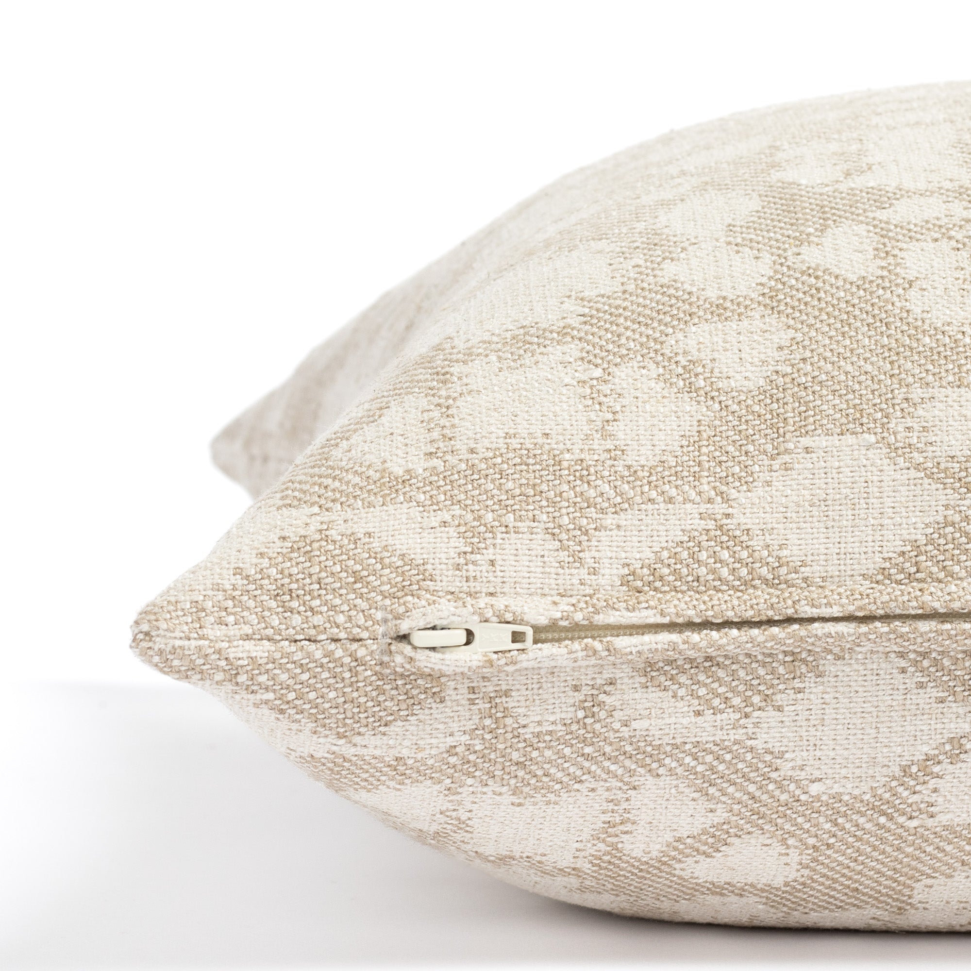 a greige and cream abstract floral print throw pillow: close up zipper detail