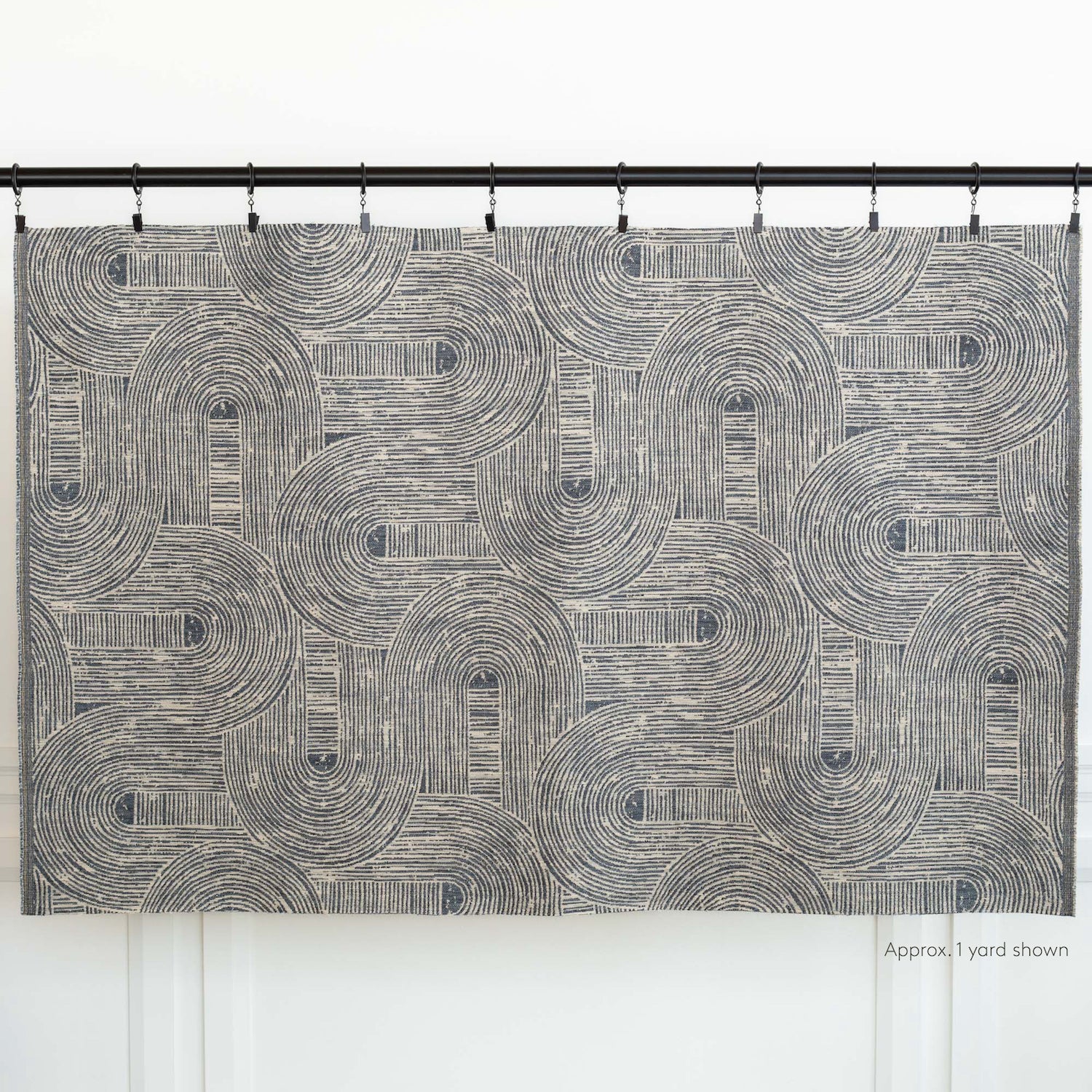 Bayside Fabric Indigo, a dynamic blue and warm grey swirling arches patterned upholstery fabric: one yard shown