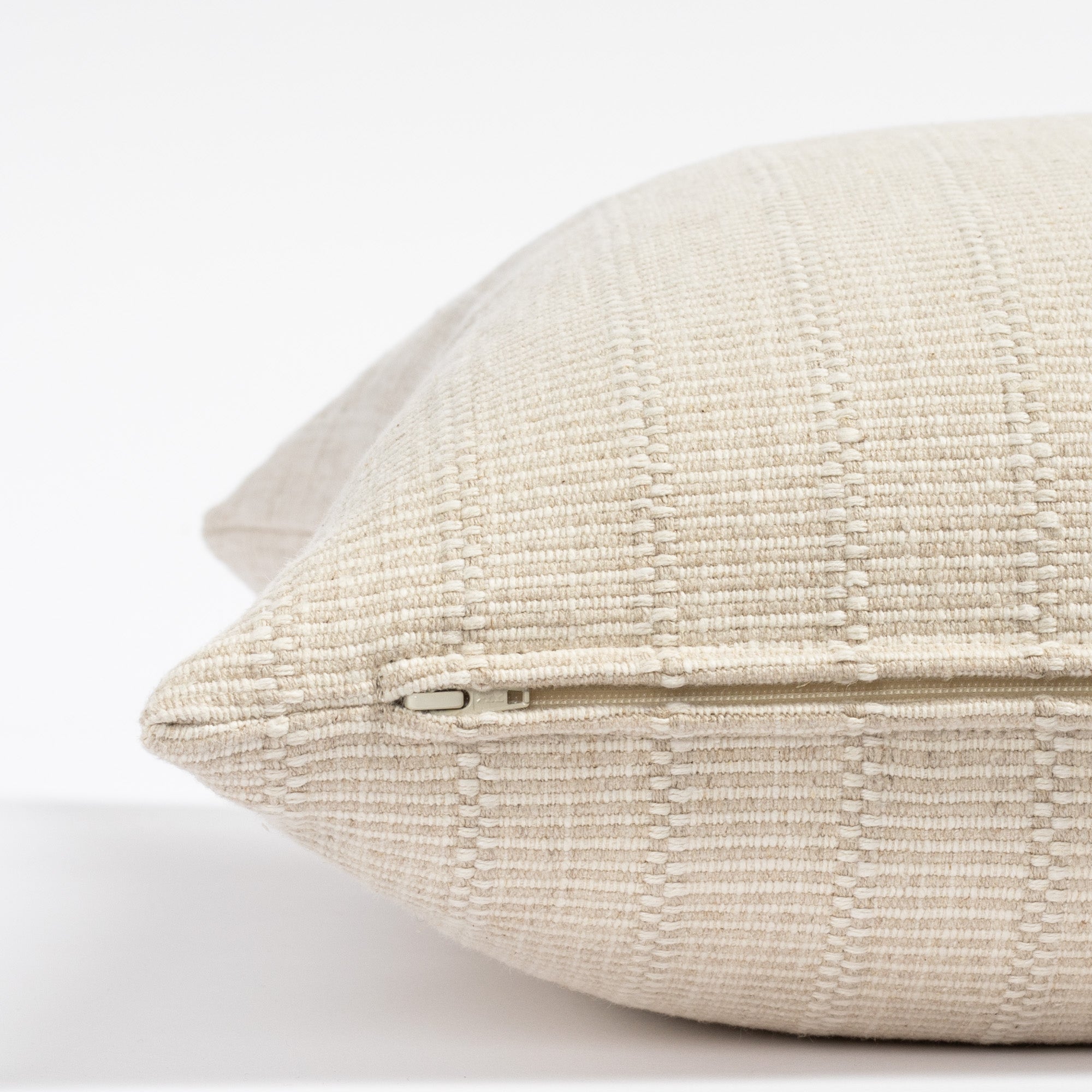 a cream tone-on-tone textured stripe throw pillow : close up zipper view