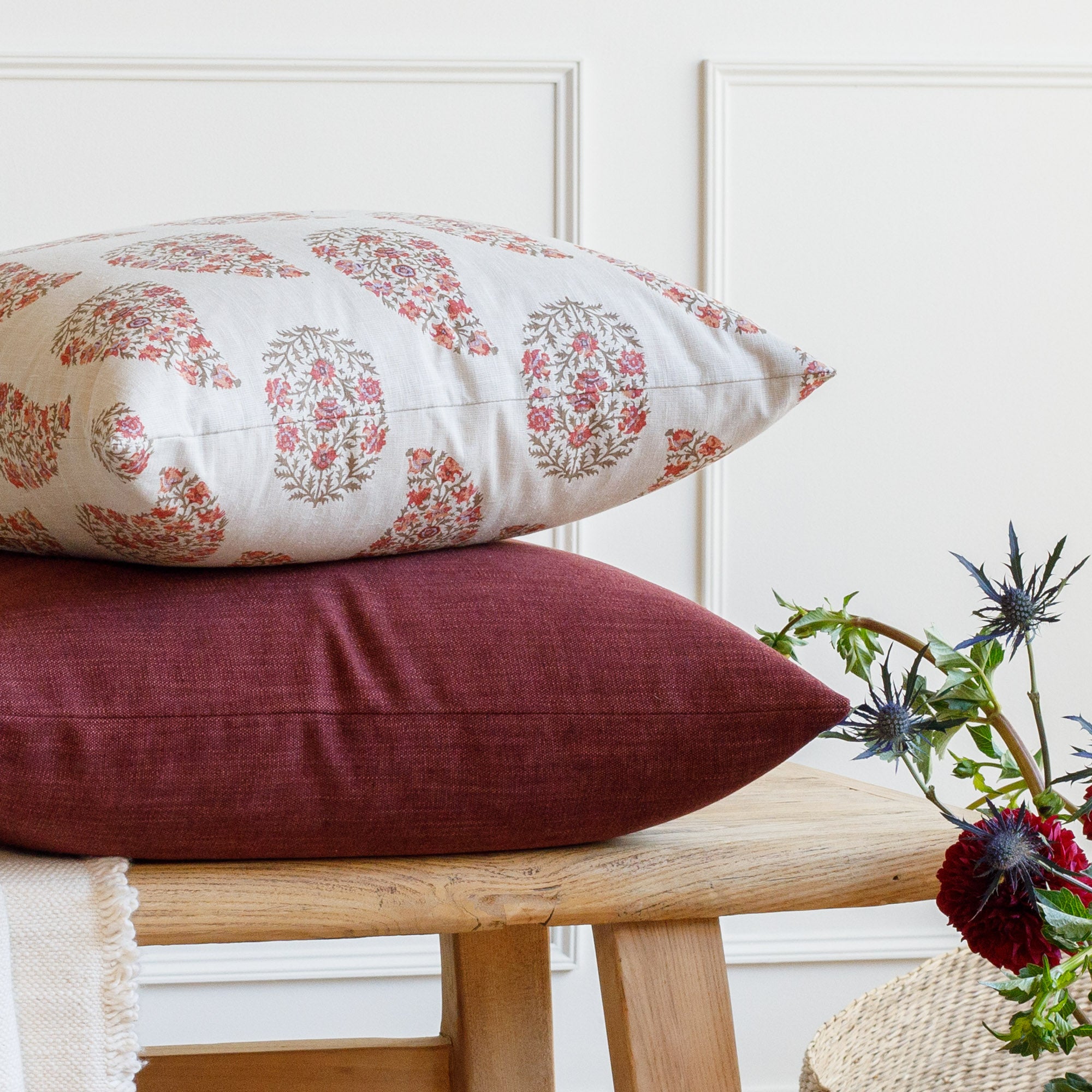 Stacked Tonic Living pillows: Bedford Merlot burgundy pillow with Grace Rosewood paisley pillow styled on a bench.