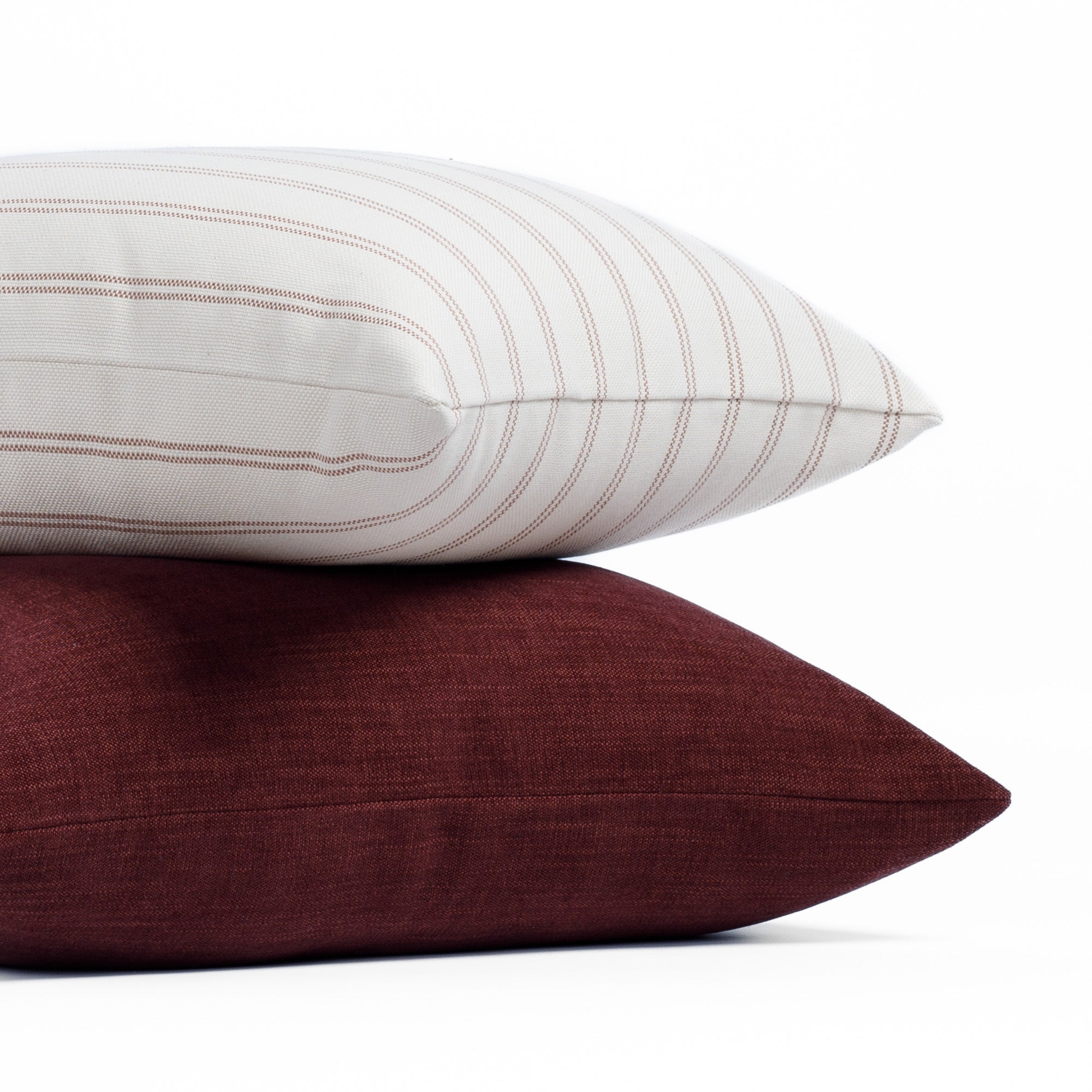 Stacked pillows: Rexton Stripe 20x20 Merlot with Bedford 22x22 Merlot red pillow by Tonic Living.