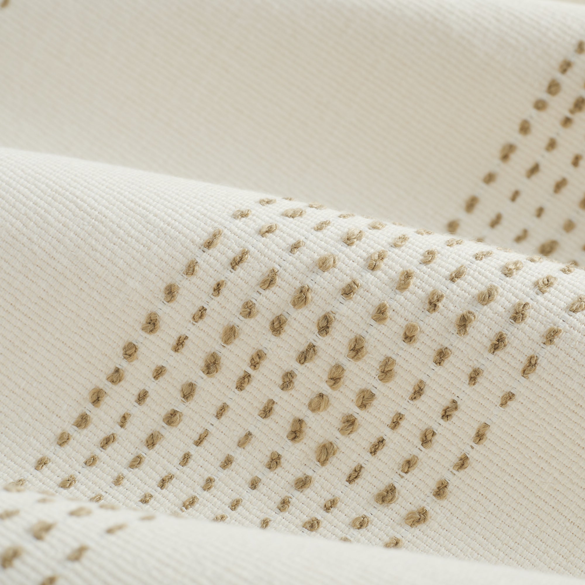 Close up of Tonic Living Caper Sunbrella Linen fabric showing raised stitched stripe detail in creamy white and light brown.