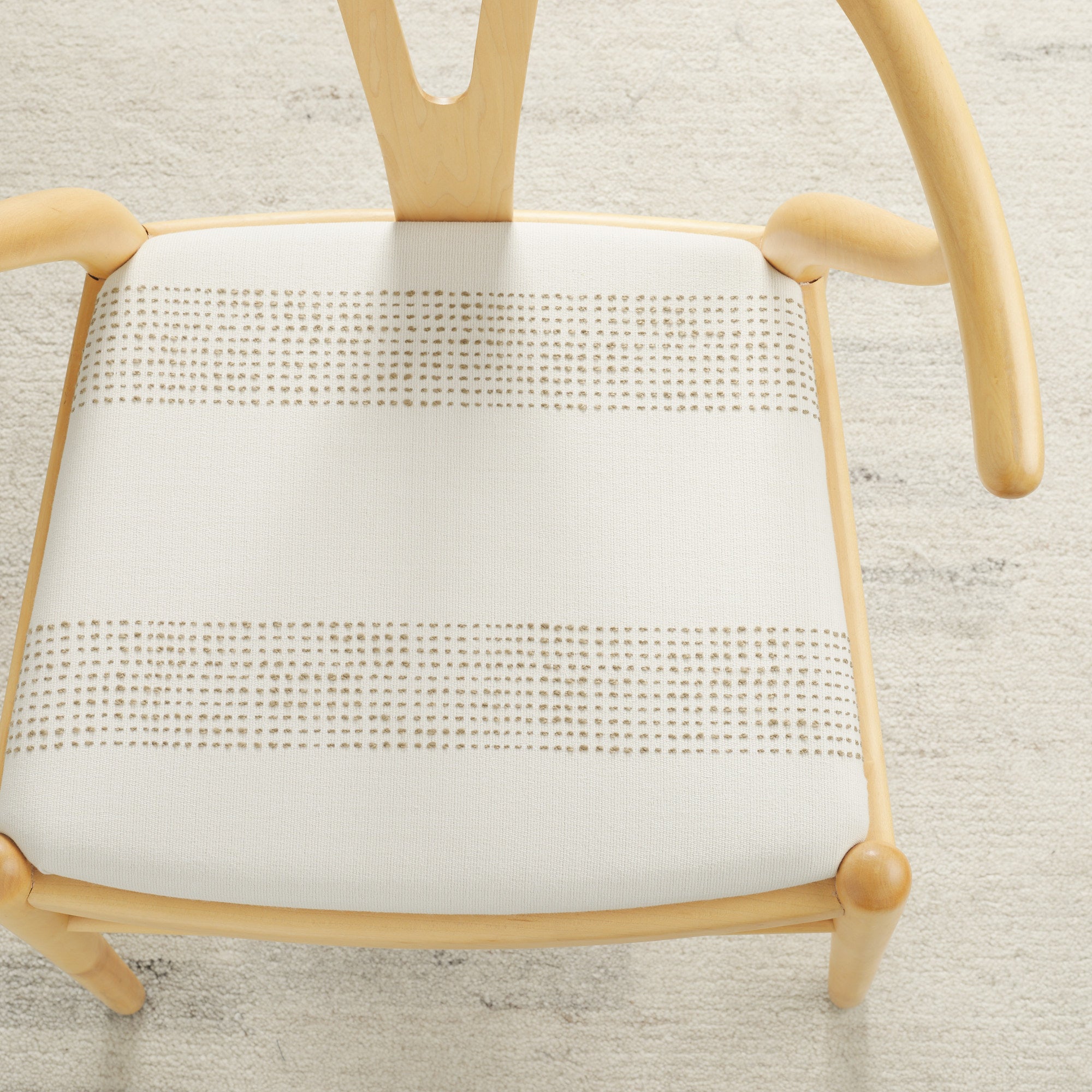 Tonic Living Caper Sunbrella Linen indoor/outdoor upholstery fabric on a dining chair seat in off-white and tan stripe.