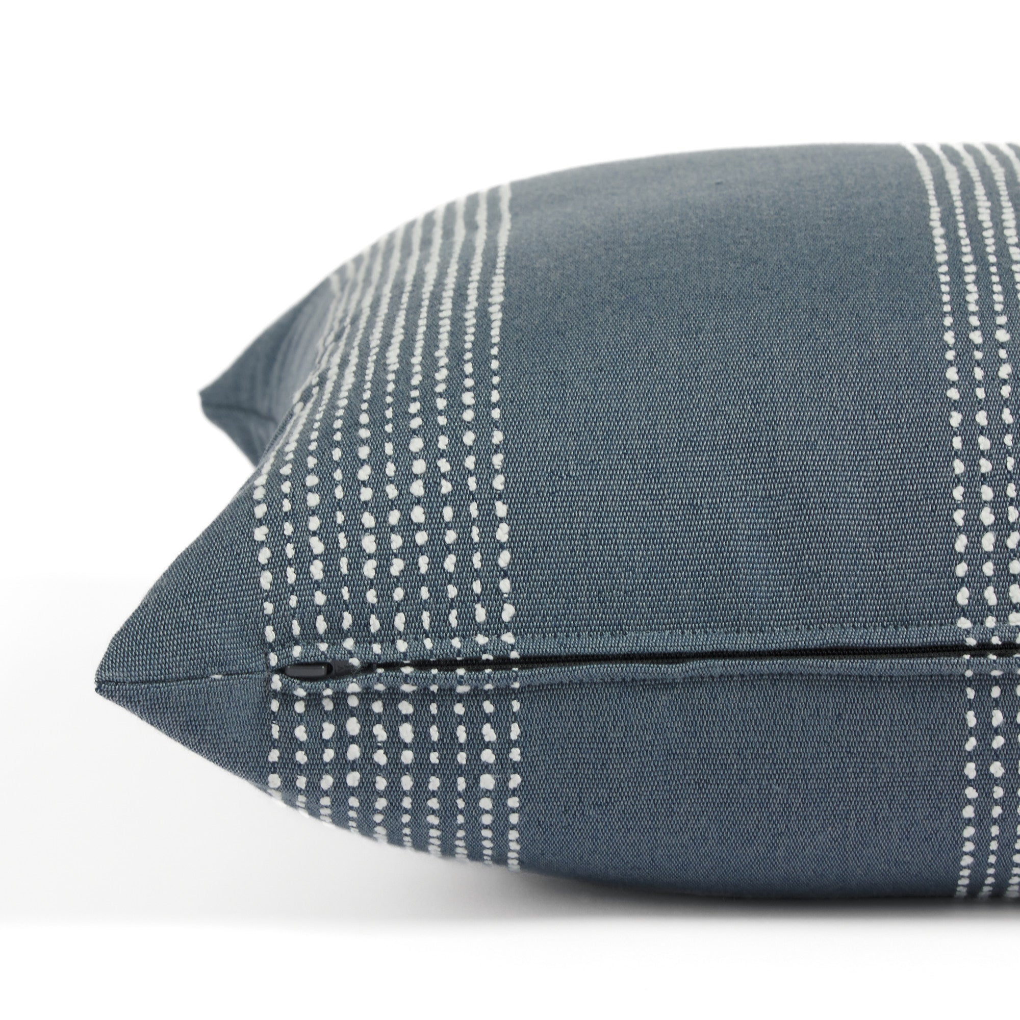 Side zipper detail of Tonic Living Caper 22x22 outdoor toss pillow in blue and white stripe.