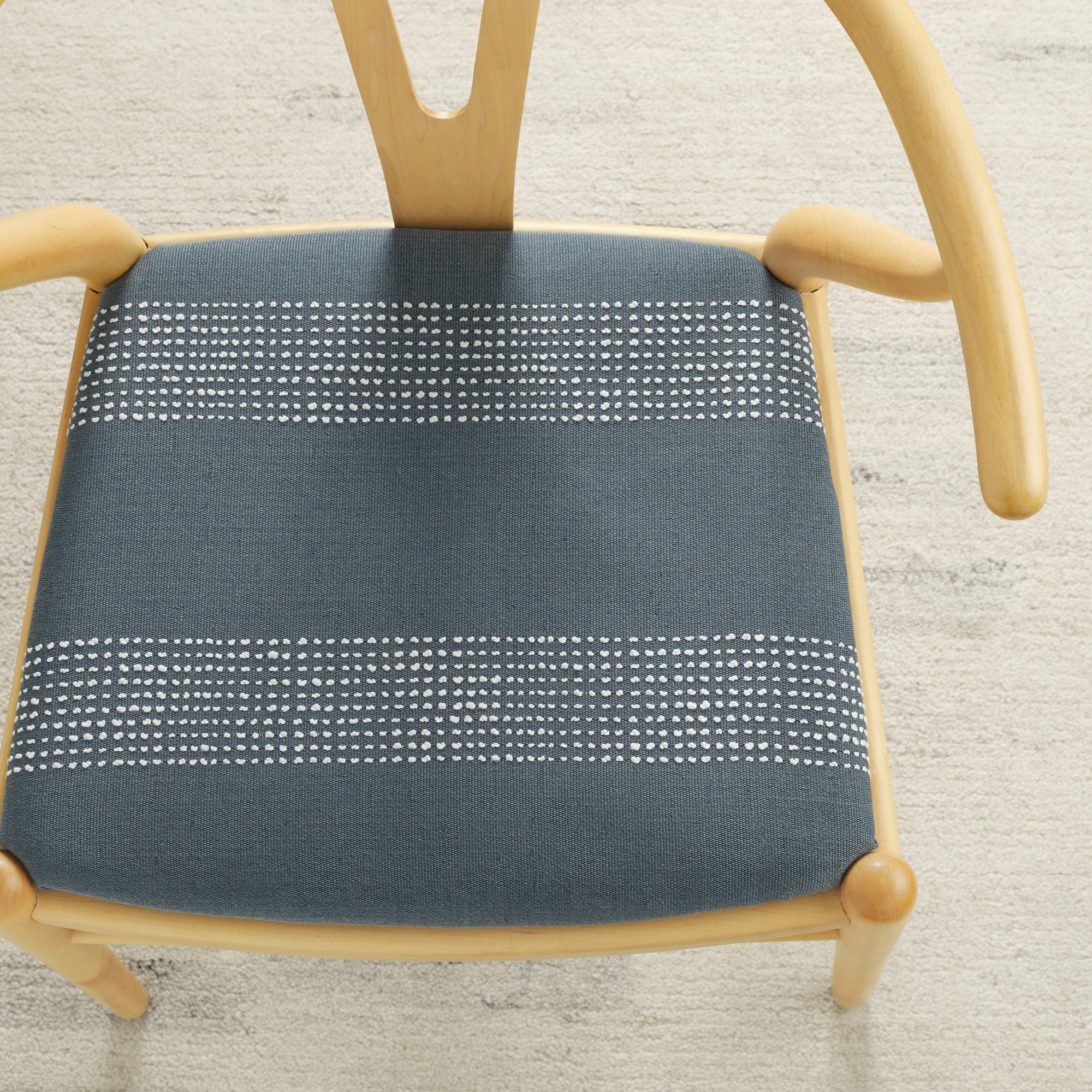 Tonic Living Caper Sunbrella Slate indoor/outdoor upholstery fabric on a dining chair seat in blue and white stripe.