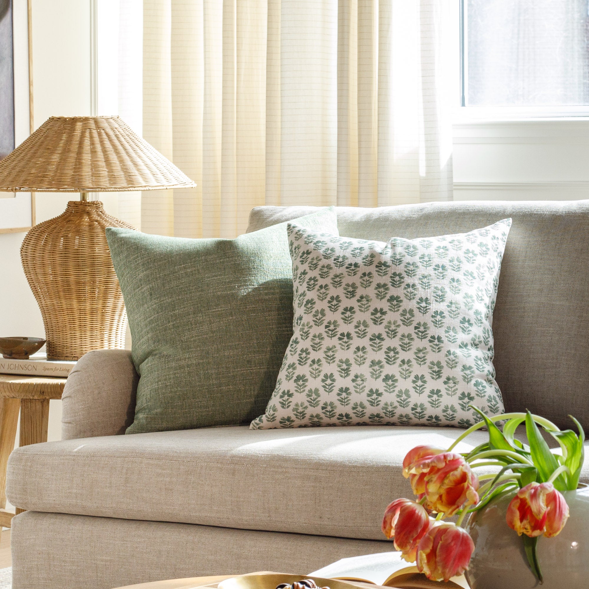 Green designer pillows from Tonic Living, styled on a couch.
