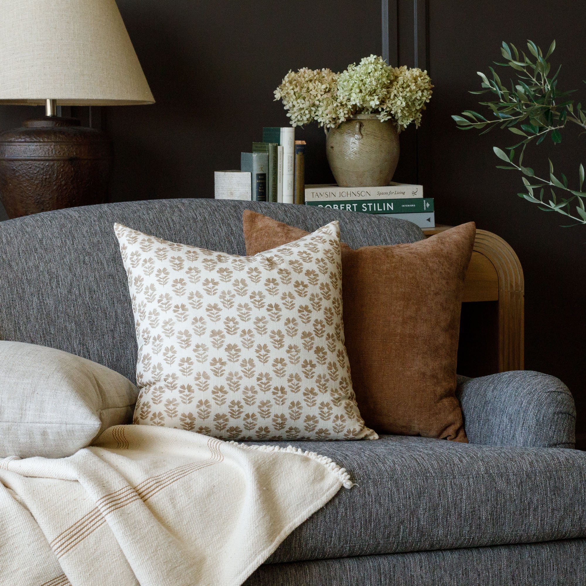 cinnamon brown and cream Tonic Living pillows on a dark grey sofa