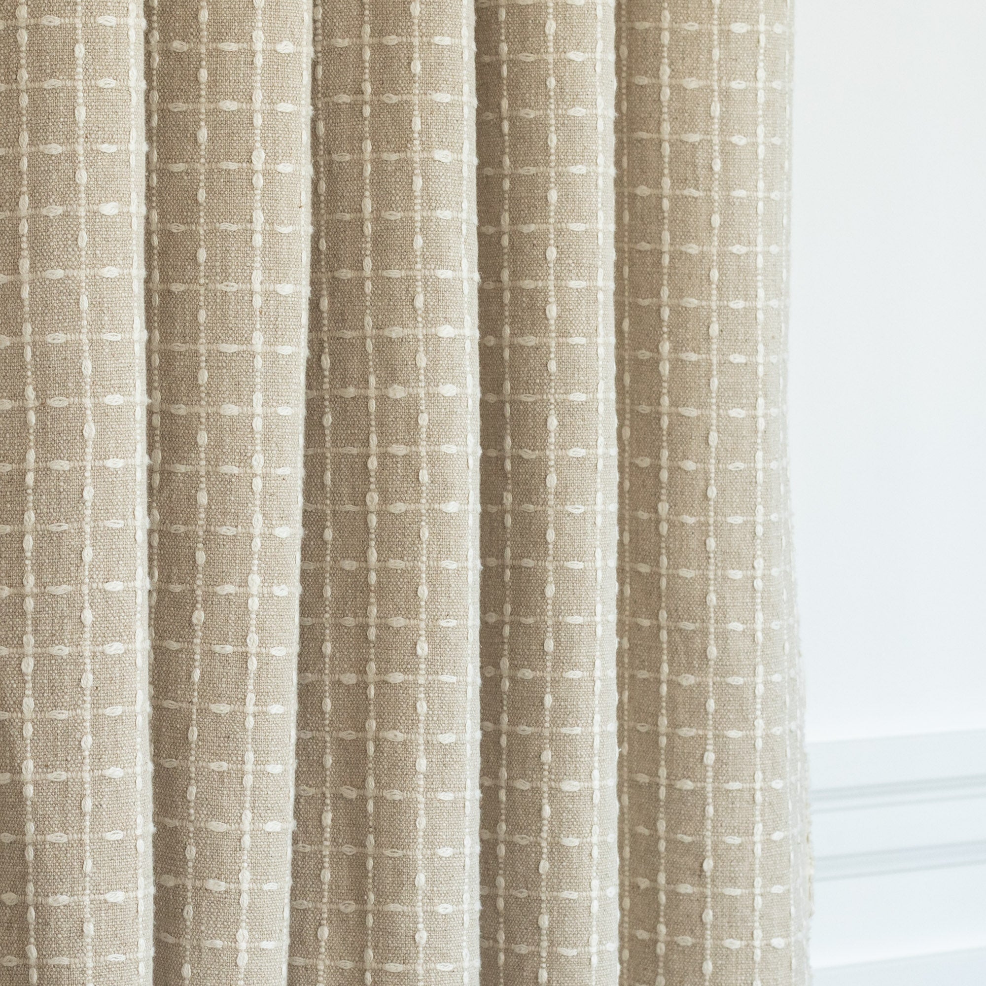 a cotton linen beige with cream windowpane stitch pattern drapery fabric from Tonic Living