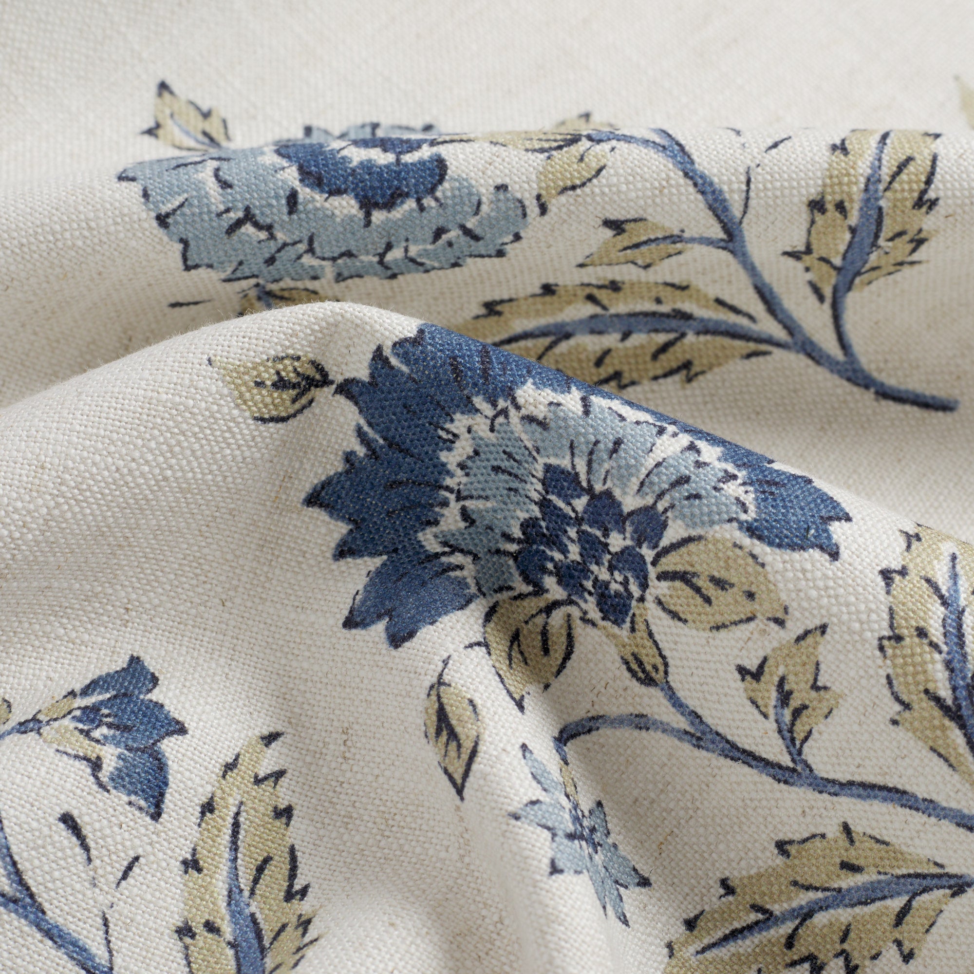 Close up of Tonic Living Clara Denim fabric showing dark blue, light blue, white, and taupe floral detail.