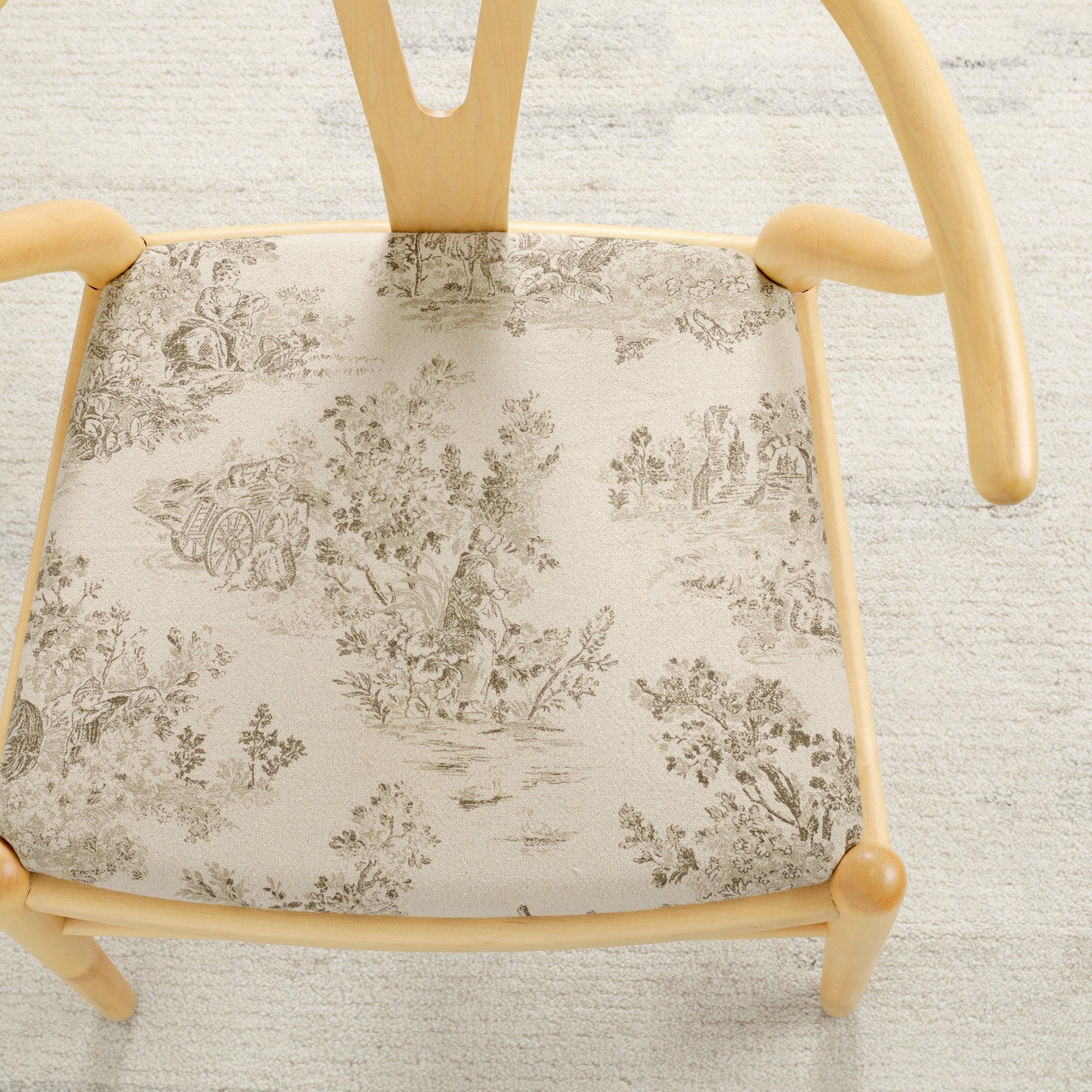 Tonic Living Colette Portobello upholstery fabric shown on a chair seat with a French toile pattern.