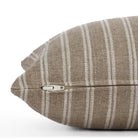 Side view of the Conway Stripe Bark 12x24 lumbar cushion by Tonic Living, showing the exposed zipper and slubby natural fabric in soft brown and beige tones.