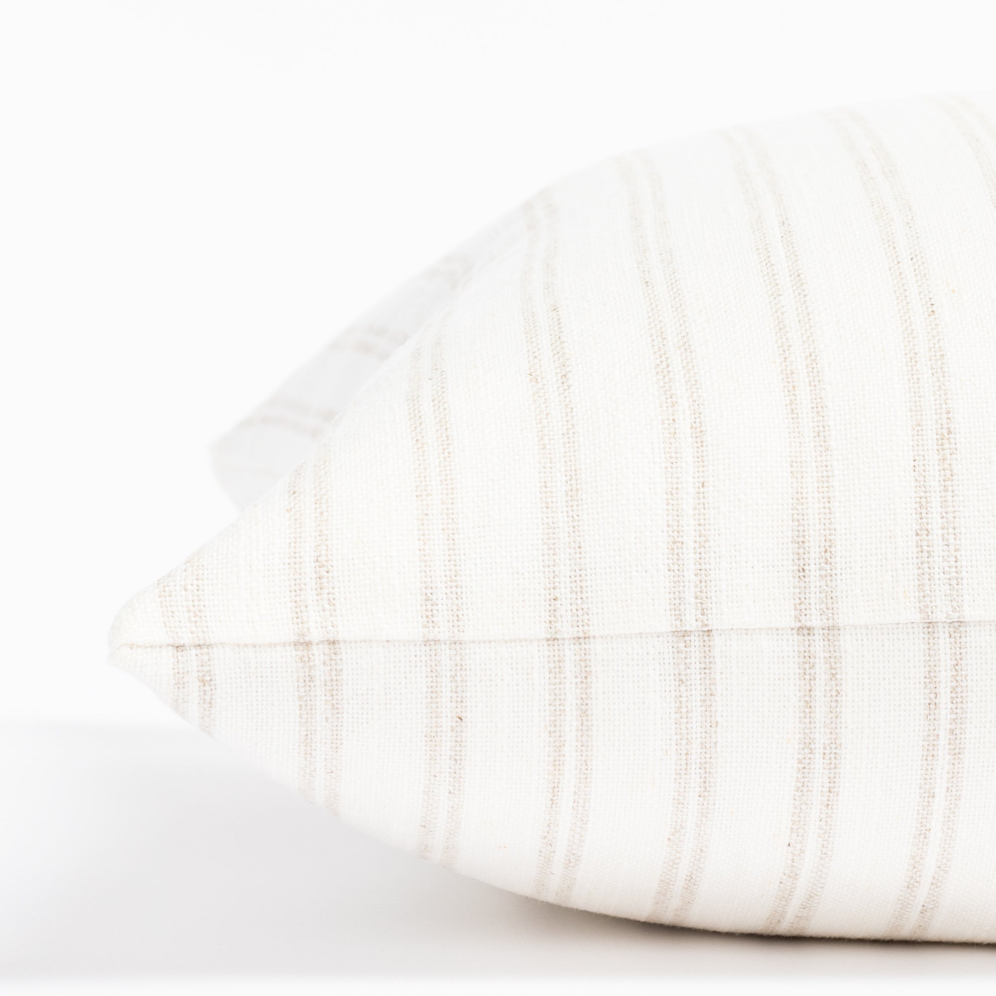 a soft white and beige vertical stripe style throw pillow : close up side view