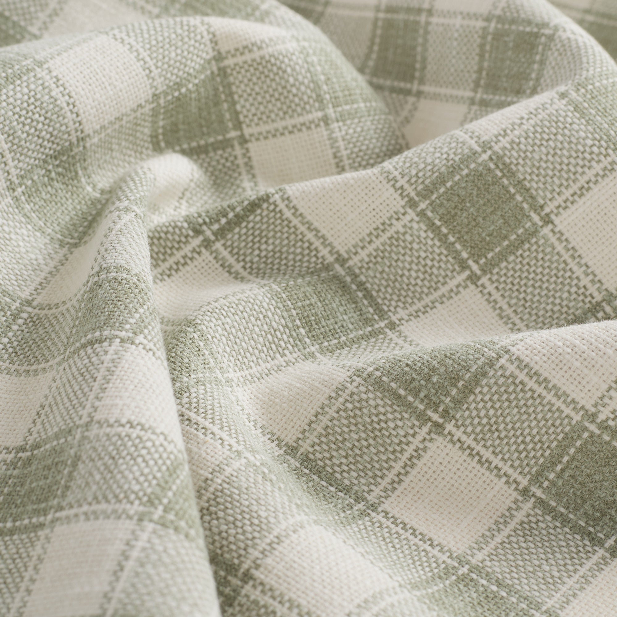 Close up of Tonic Living Emmett Plaid Sage fabric featuring a timeless light green plaid pattern.