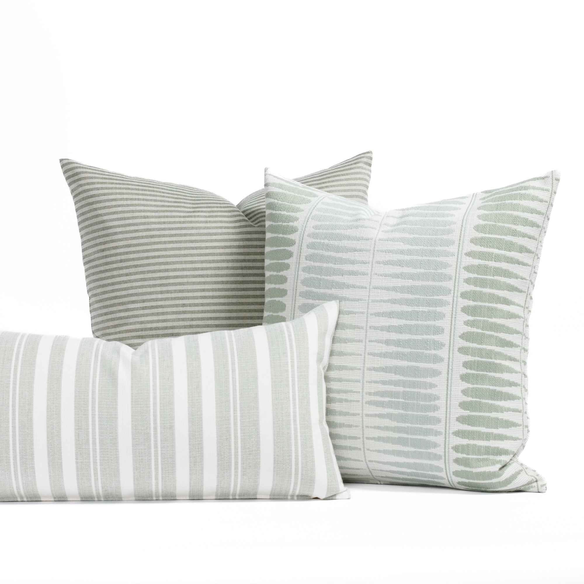 A selection of soft sage green, misty aqua and white indoor/outdoor throw pillows from Tonic Living.
