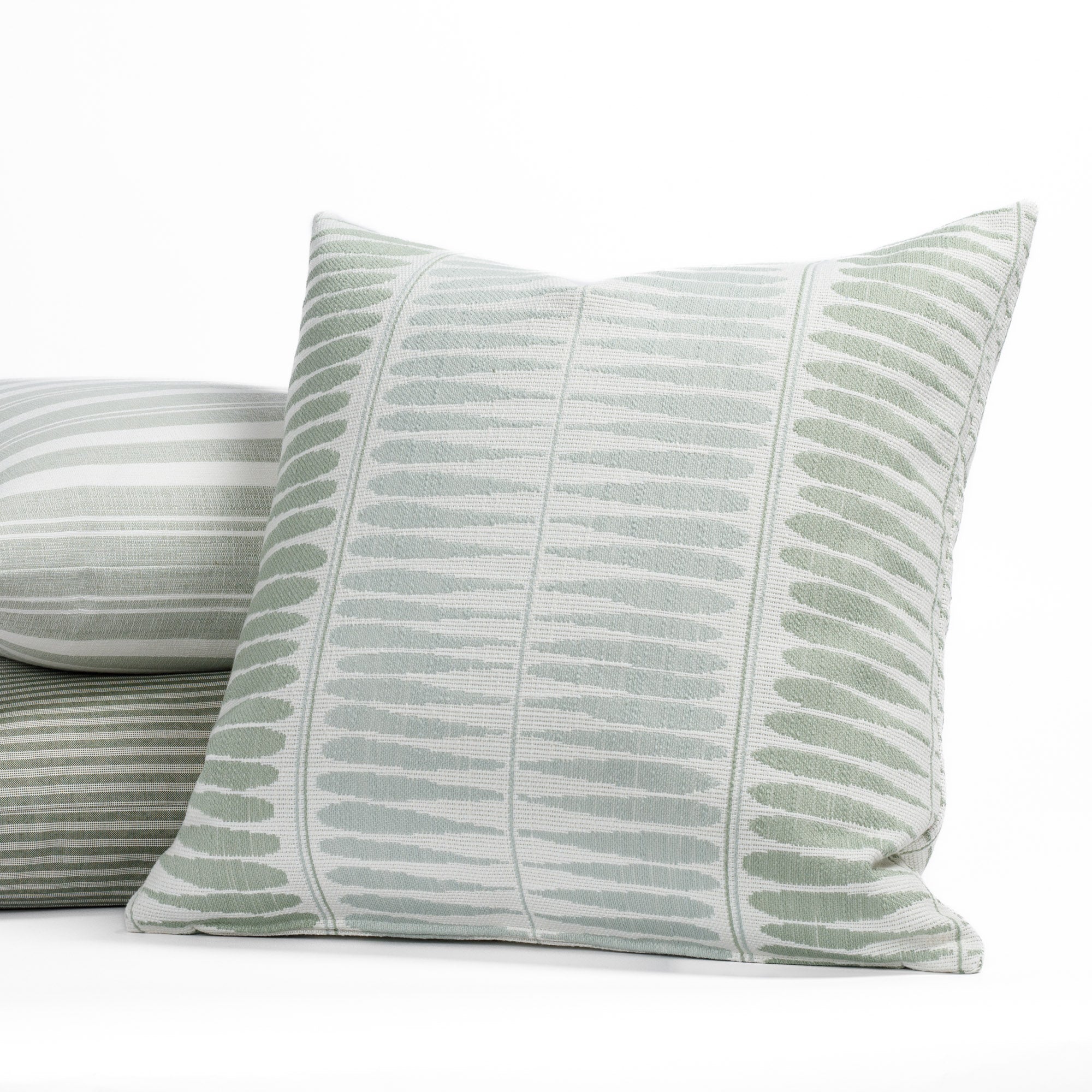 A selection of of misty aqua blue, light green and white indoor/outdoor throw pillows from Tonic Living.