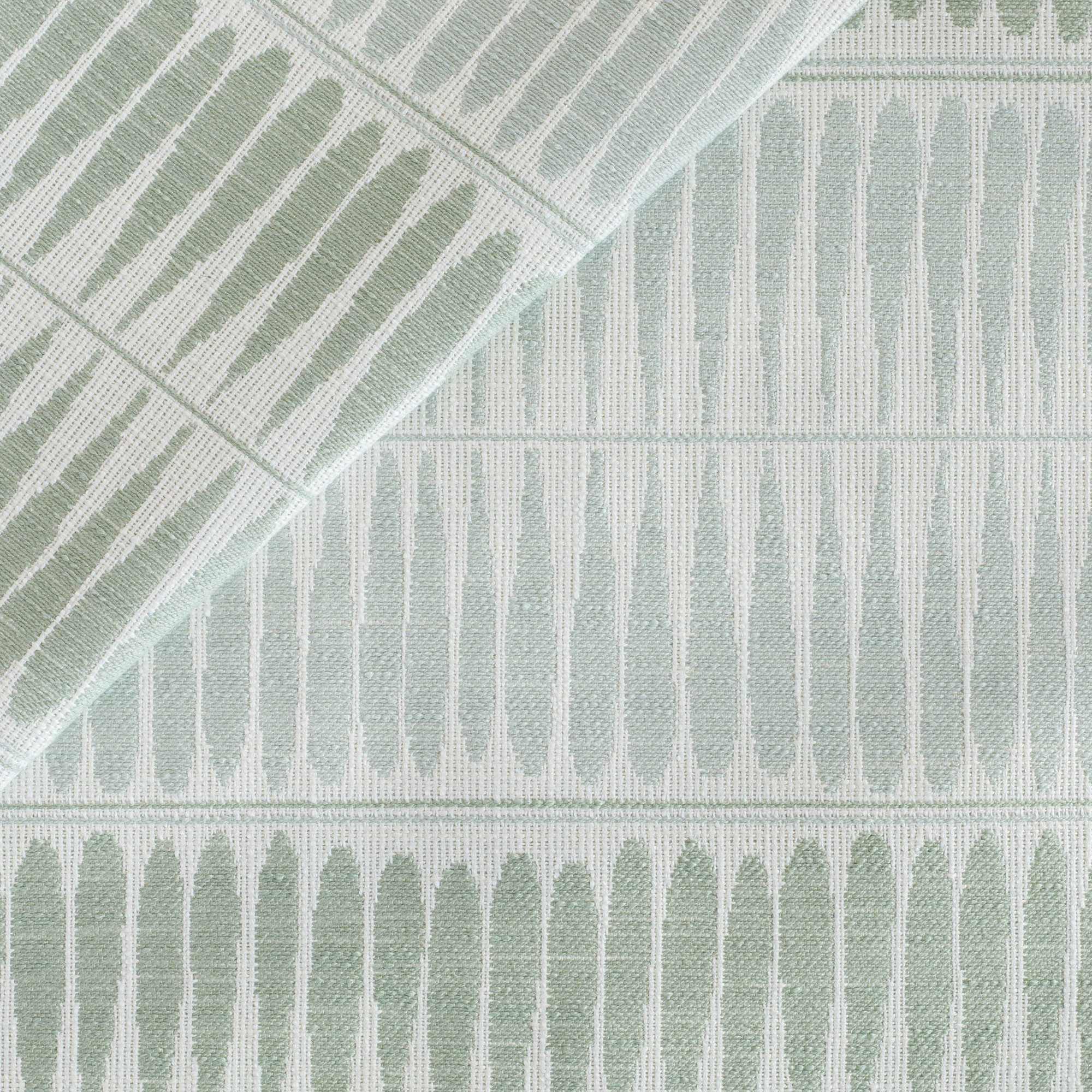 An indoor/outdoor upholstery fabric from Tonic Living, featuring soothing blue and green elongated teardrop shapes.
