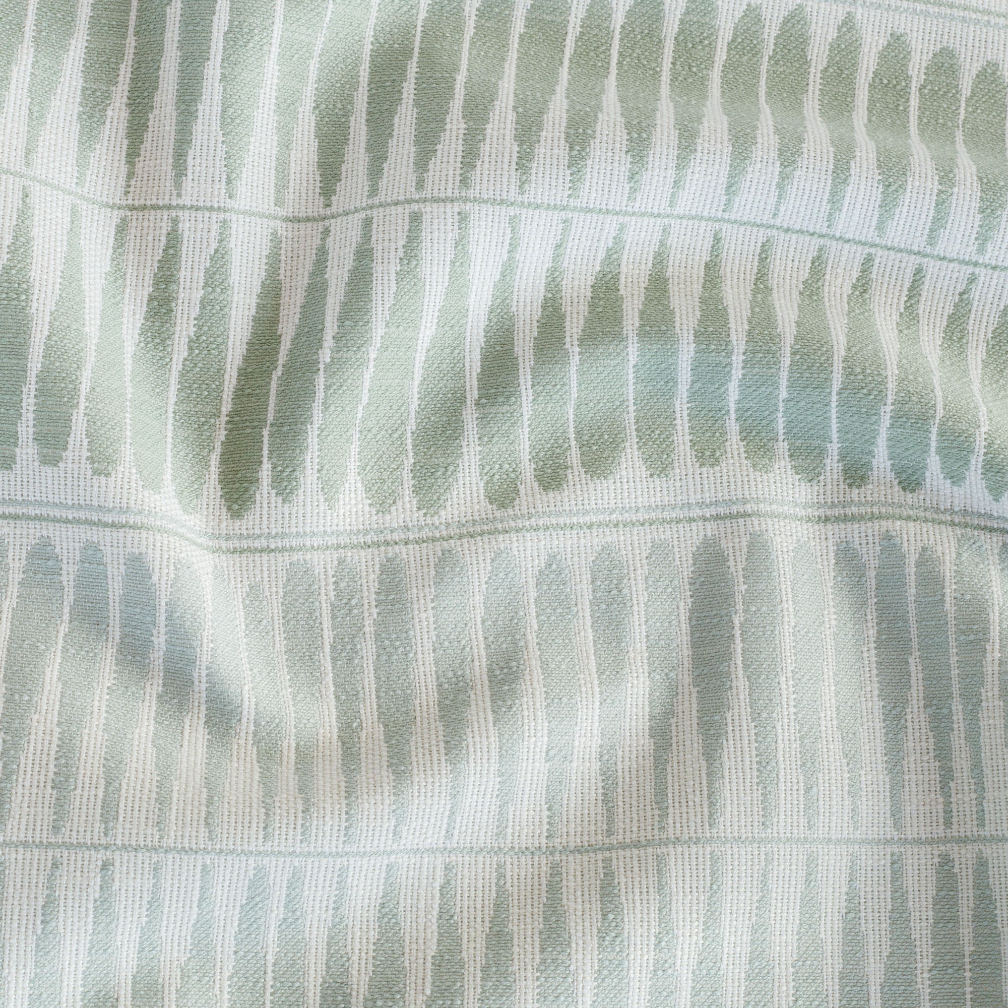 Everly Jade Outdoor fabric from Tonic Living, a pale sage green, dusty aqua blue and soft white upholstery fabric with organic shapes.