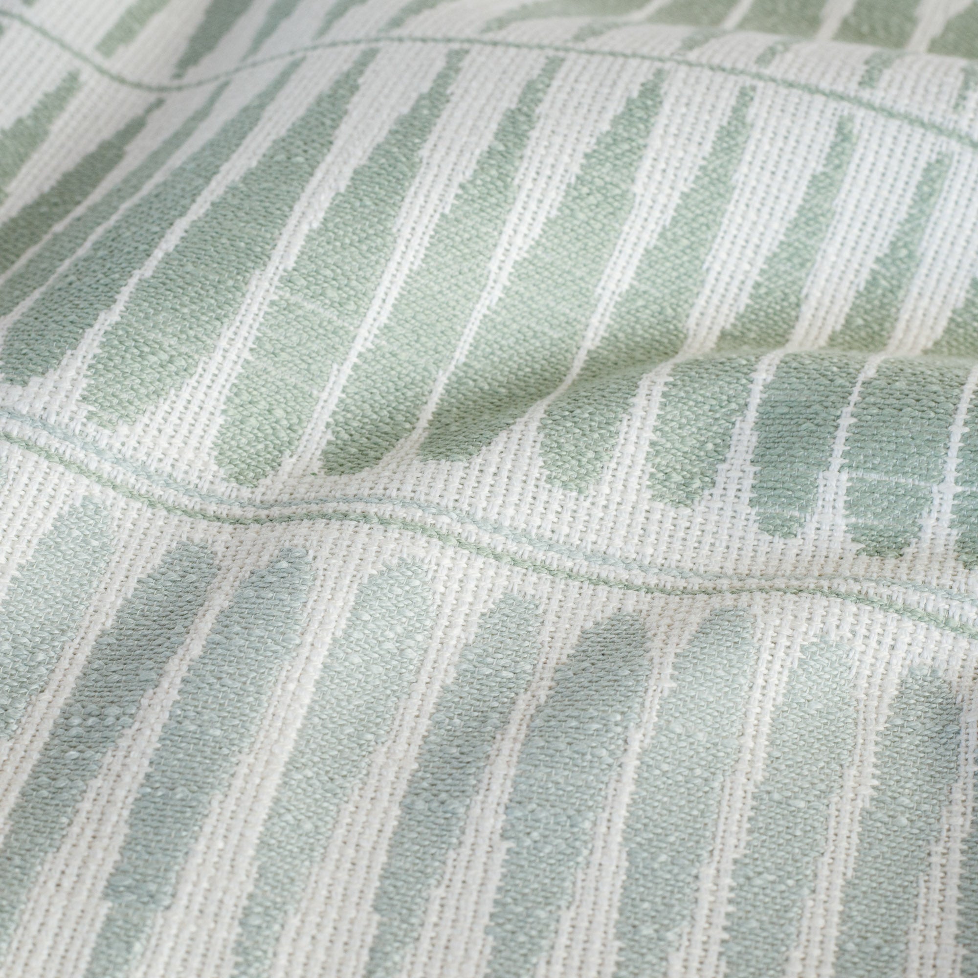 Everly Jade, an indoor/outdoor fabric with organic leaf shapes in mint green and pale aqua: close up view.