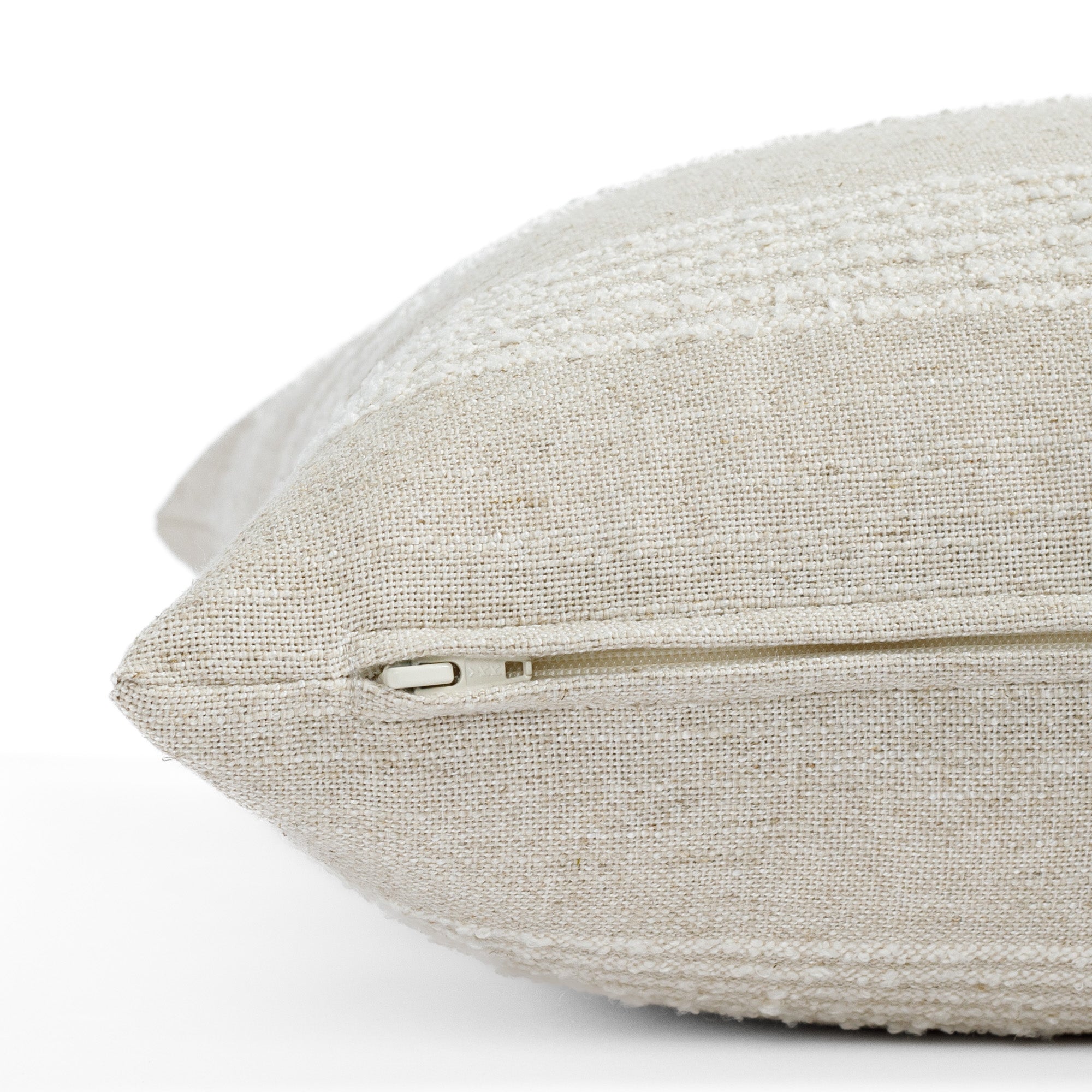 an off white and oatmeal striped pillow : close up zipper view