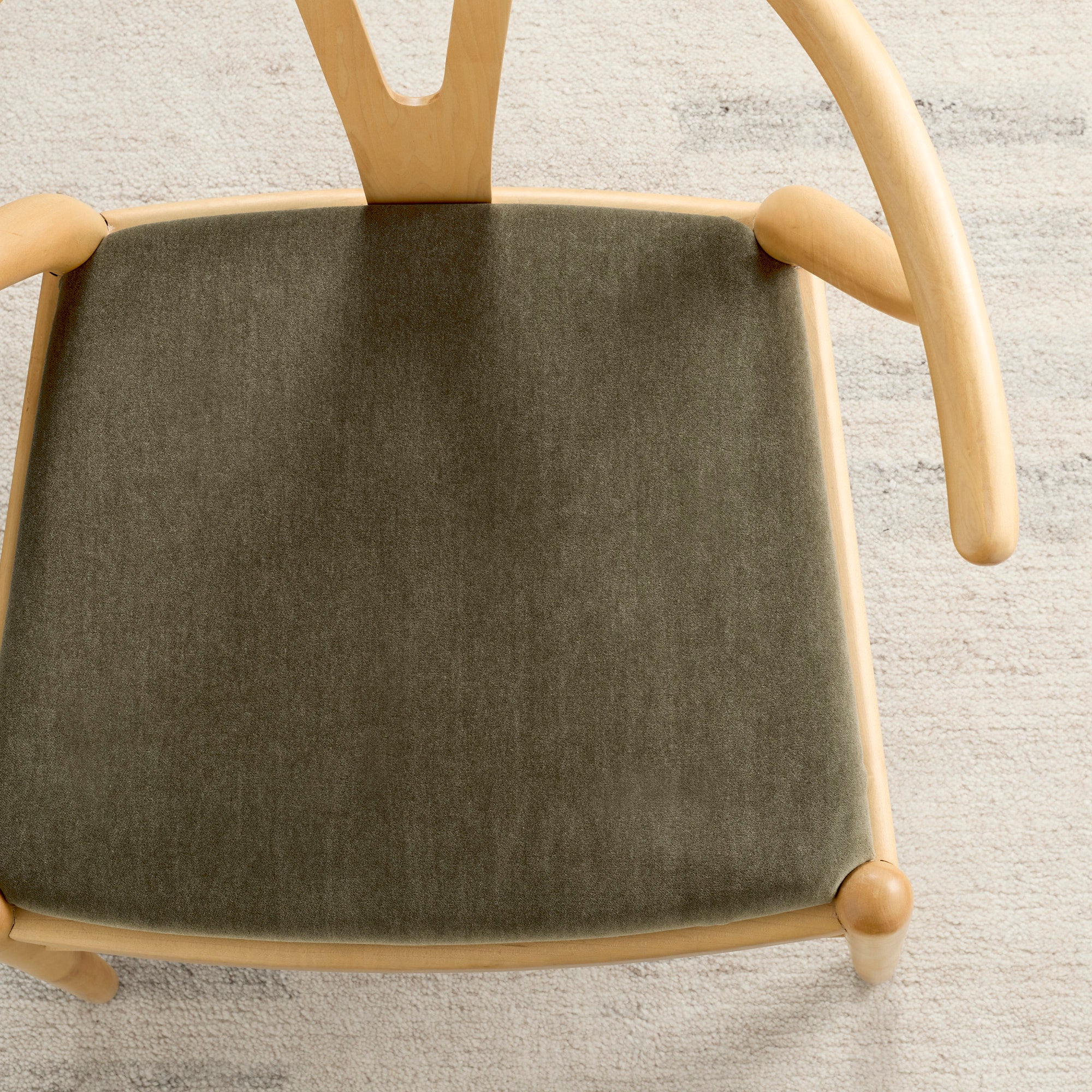 Tonic Living Florence Velvet Olive upholstery fabric shown on a dining chair in smoky green velvet.