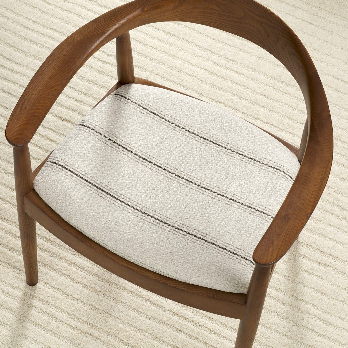 Tonic Living Gibson Stripe Birch high-performance fabric shown upholstered on a dining chair seat with classic neutral stripes.