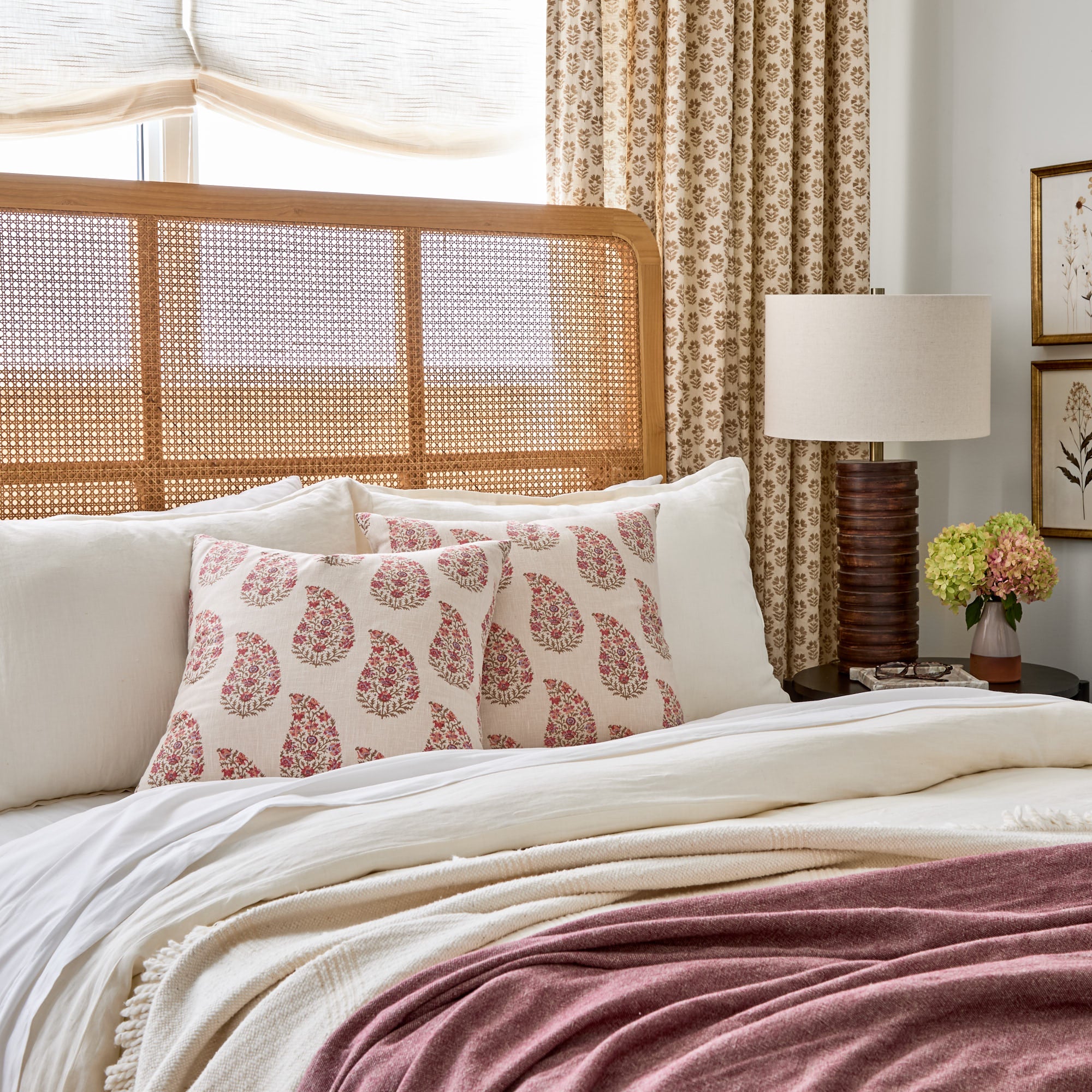 Tonic Living Grace 20x20 Pillow, Rosewood styled on a bed, featuring pink & red floral paisley pattern.