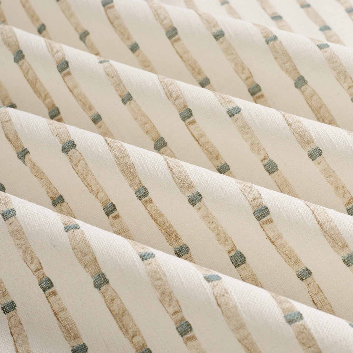 Close up of Tonic Living Hadley Stripe Fabric shown rippled, highlighting its blue and brown bamboo-inspired stripe pattern.