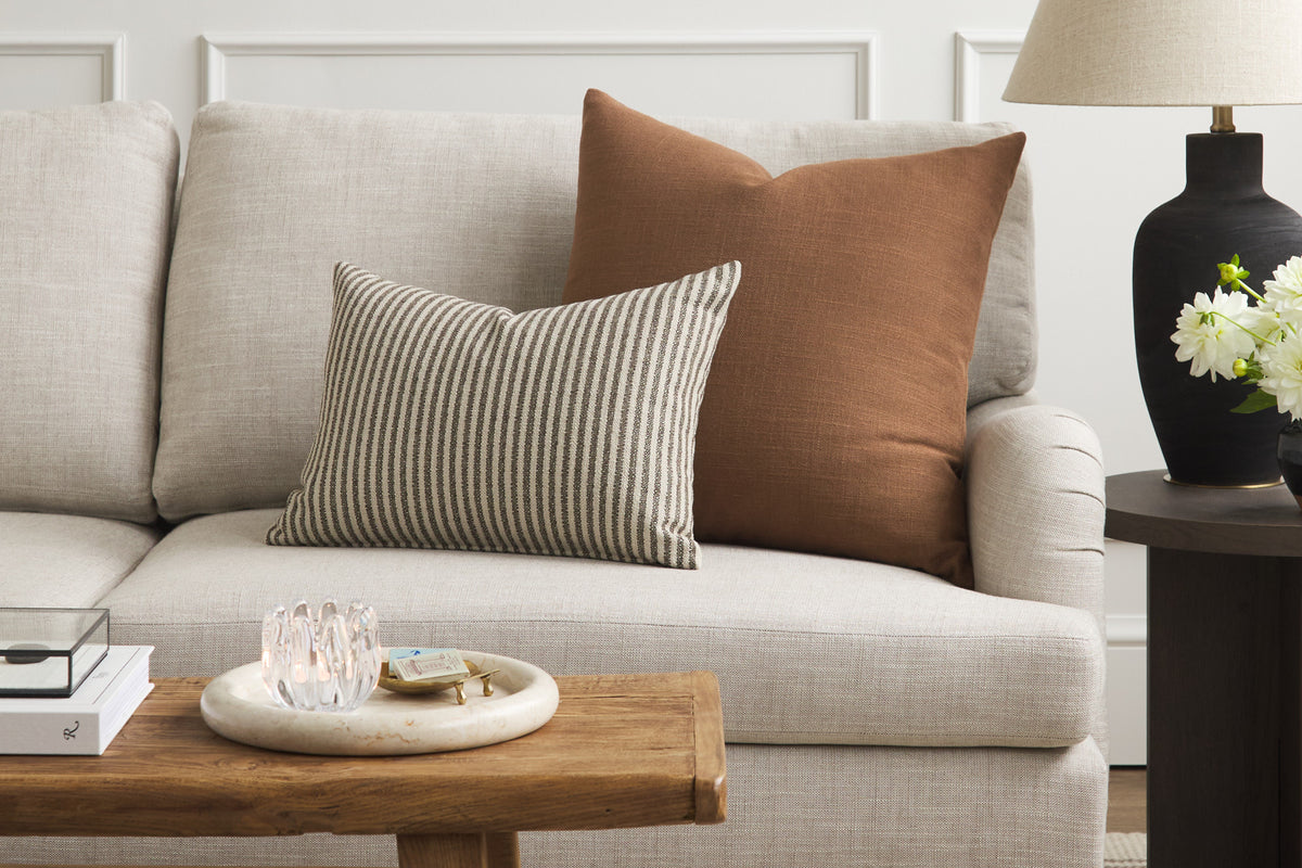 Tonic Living Hampton Cinnamon brown decorative pillow styled on a sofa with a neutral Crosby Stripe lumbar cushion.