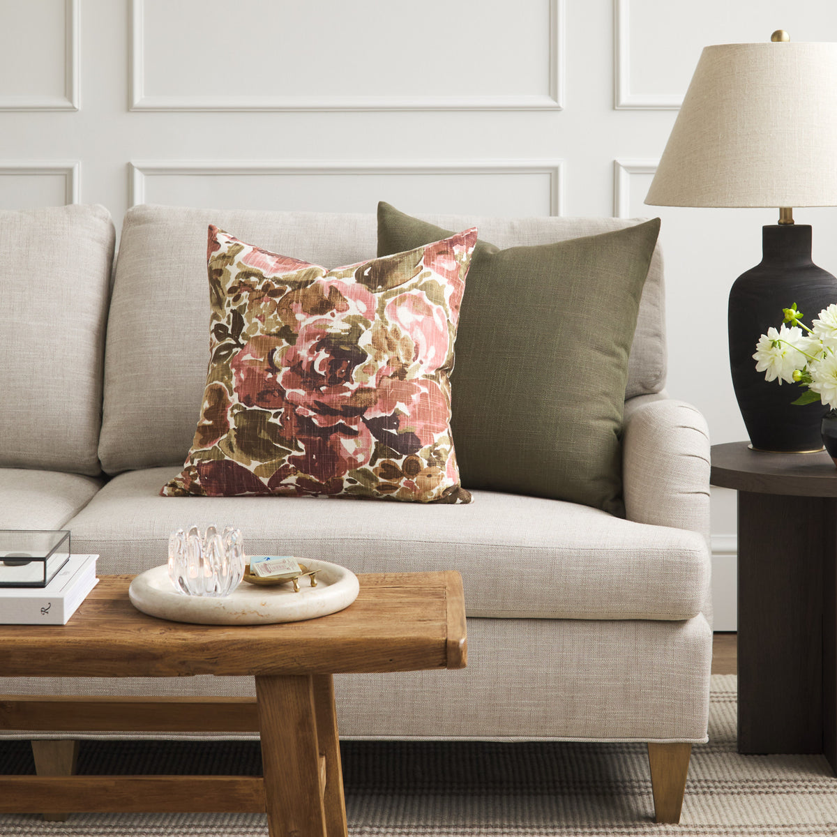 Tonic Living Hampton Moss green throw pillow styled on a sofa with Marbella Rose abstract floral cushion.