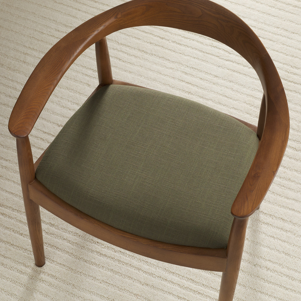 Tonic Living Hampton Moss high-performance upholstery fabric shown on a dining chair seat in a rich moss green.