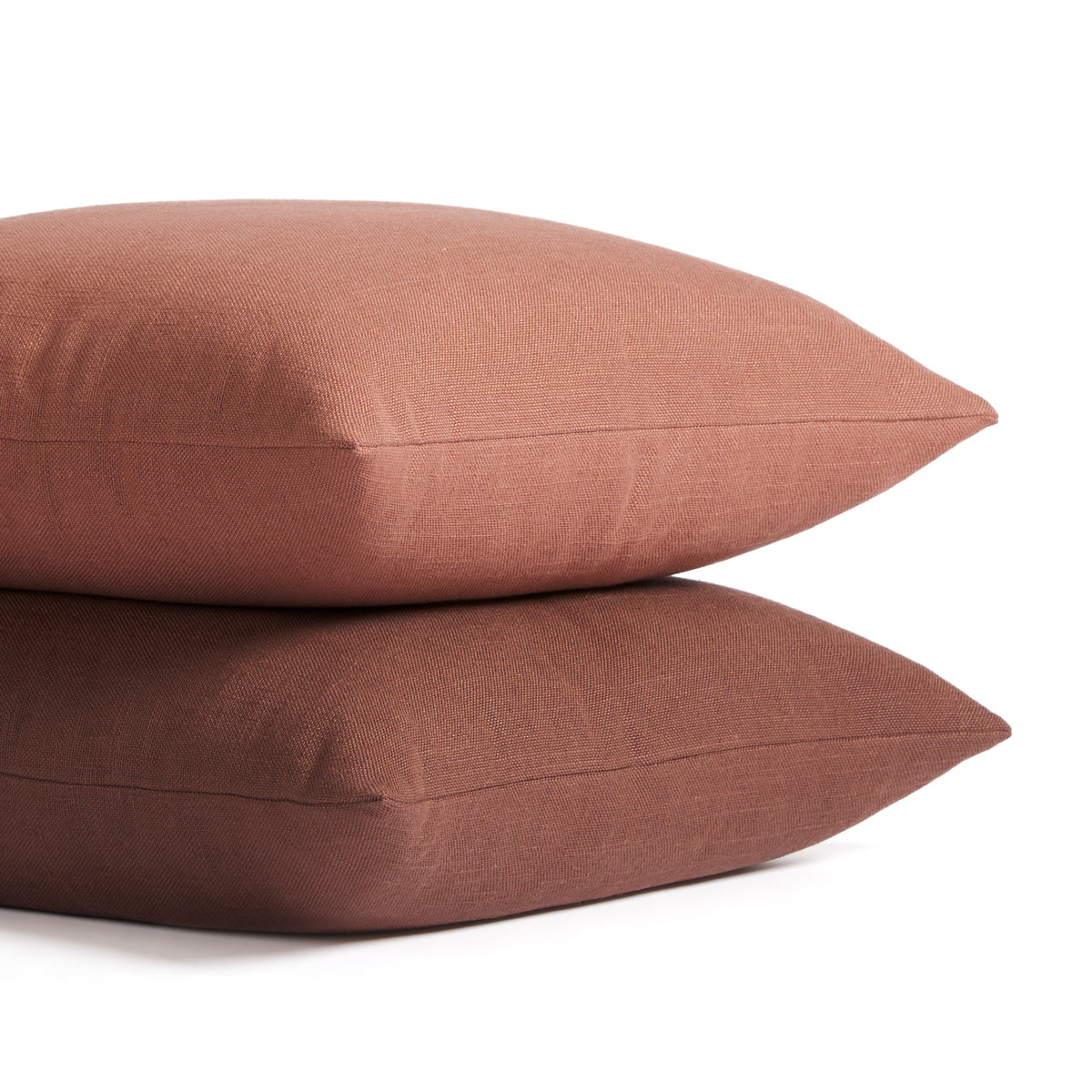 Stack of Tonic Living Hampton pillows in Rosewood earthy pink and Burgundy deep red-brown with linen-inspired texture.