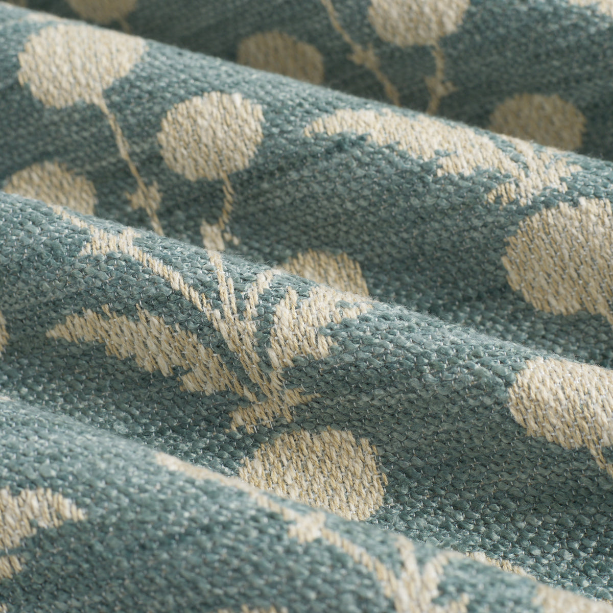 Close up of Tonic Living Hazel Pool upholstery fabric showing its muted blue-green and beige floral pattern with leafy stems and blooms.