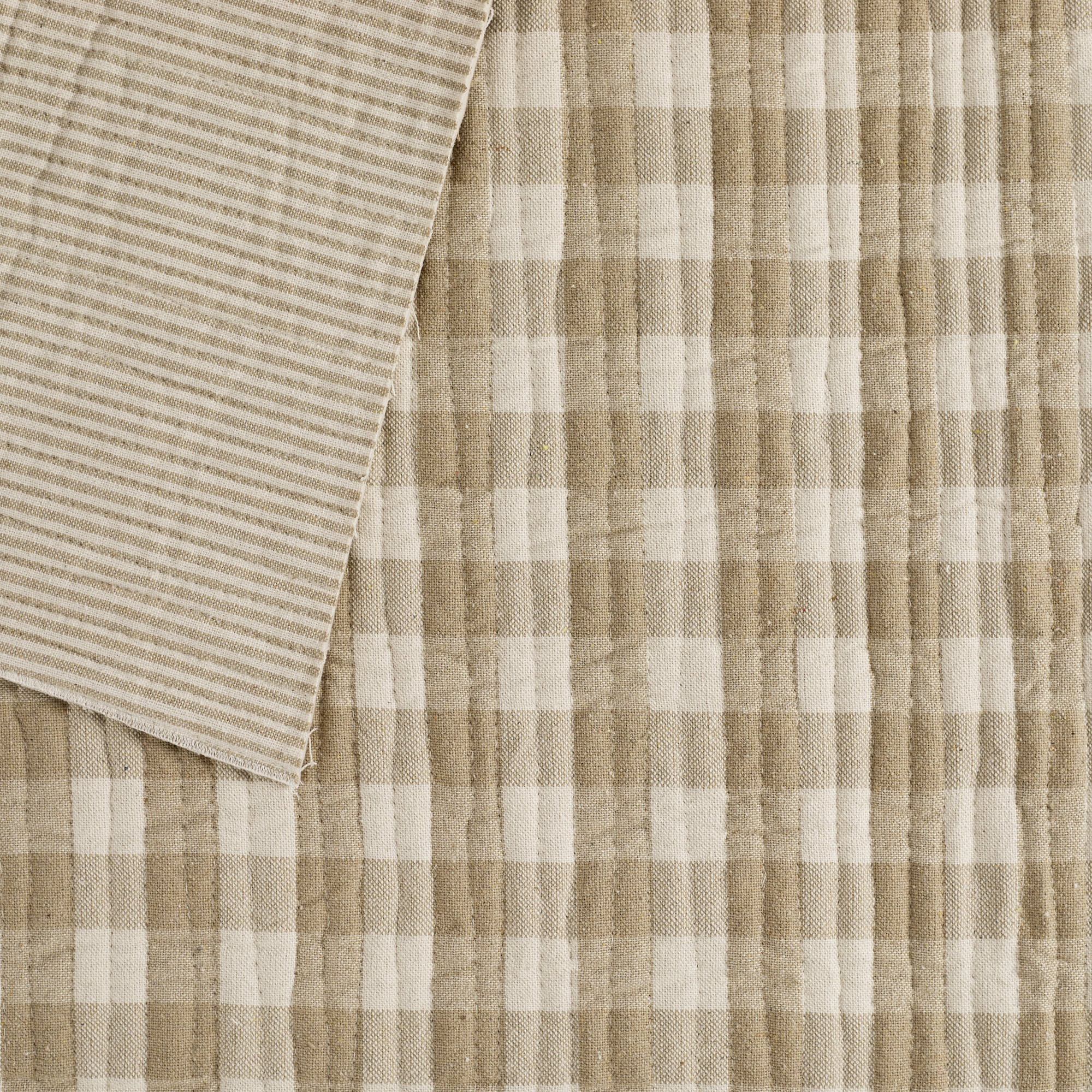 Tonic Living Henry Check Fabric in Wheat, a quilted matelassé fabric with off-white and beige gingham check and coordinating stripe reverse.