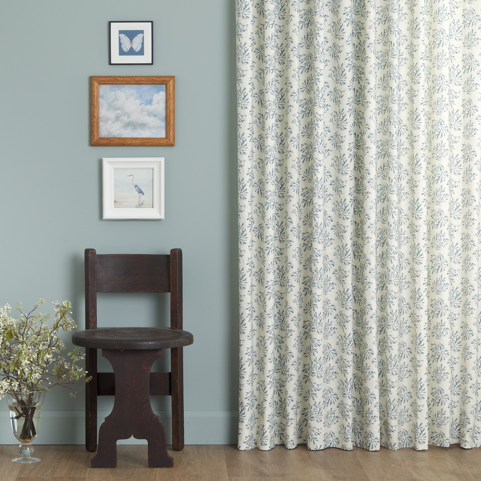 Tonic Living Juniper Harbour Blue curtain fabric shown as full drapery in a blue room with classic decor.