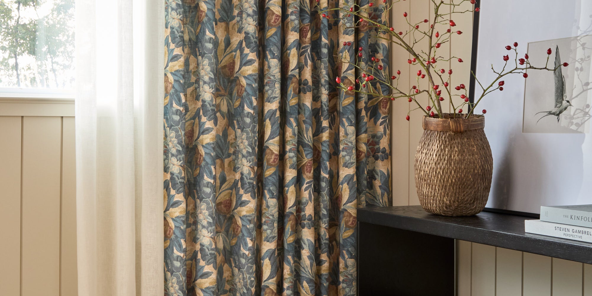 Juno Navy drapery fabric by Tonic Living — linen-blend drapery fabric with a painterly botanical floral pattern in navy and earthy tones, shown as curtains styled in a living room.