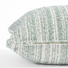 a soft white and blue green boucle striped lumbar pillow : close up zipper view