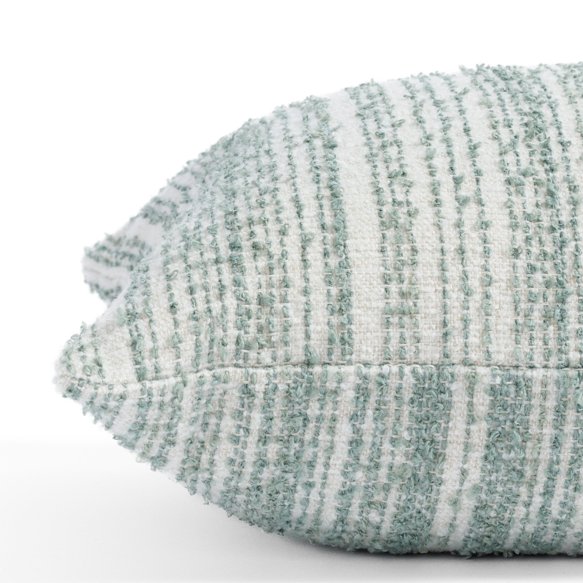 a soft white and blue green boucle striped lumbar pillow : close up side view