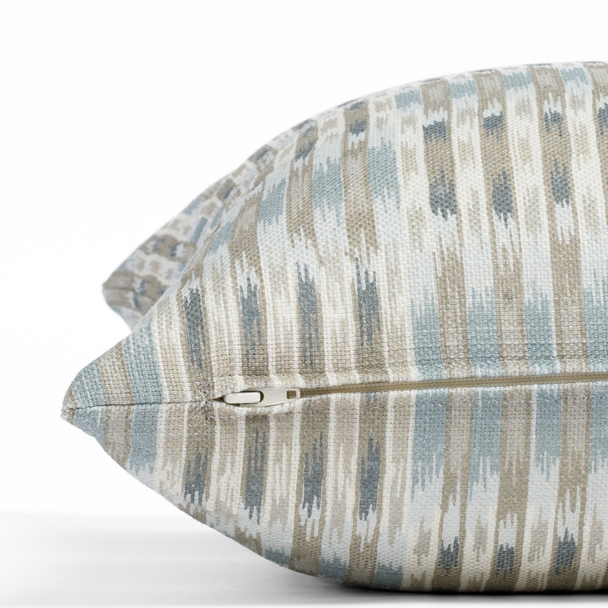 a watery blue, sand and white ikat print throw pillow : zipper detail