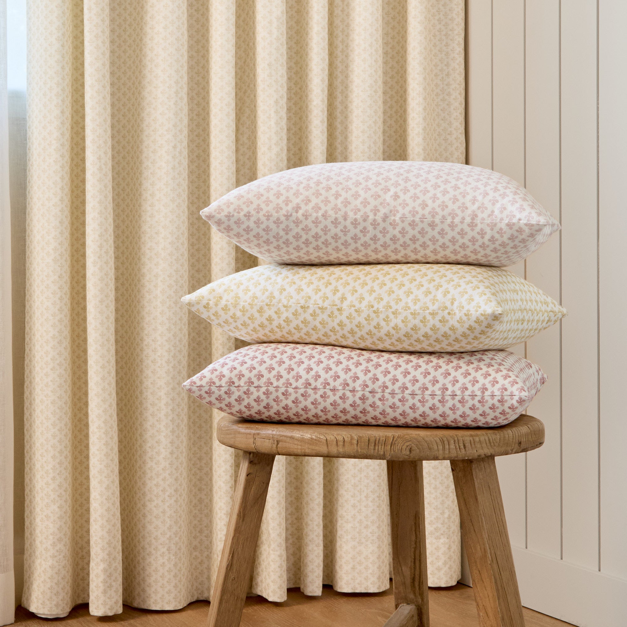 Stack of Lyra 14x20 lumbar pillows in Blush, Butter Yellow, and Berry by Tonic Living — linen-blend pillows with floral block prints.