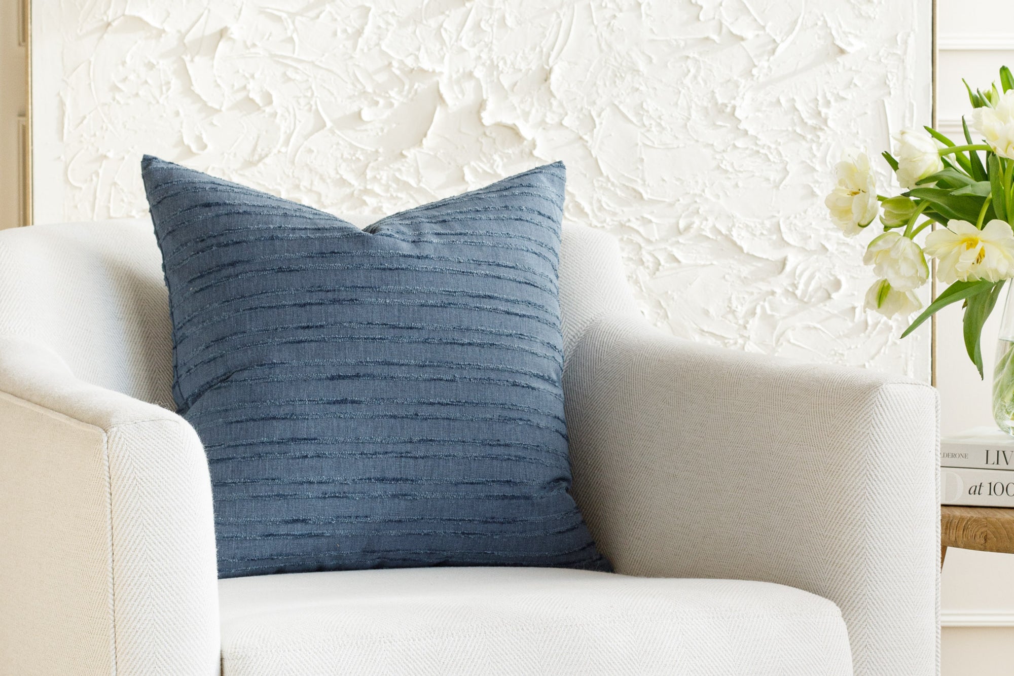 A blue pillow, styled on furniture.