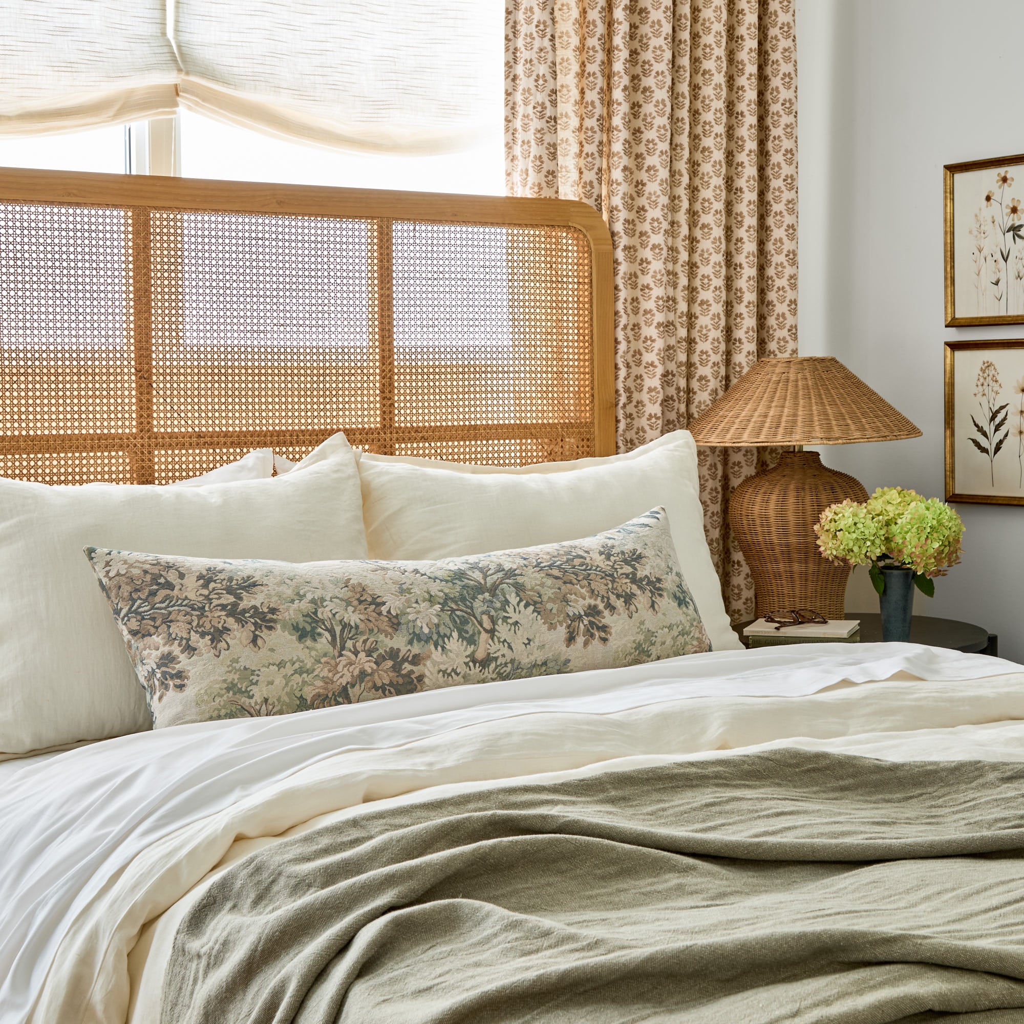 Tonic Living's Manor Tapestry 16x42 bolster pillow in sage green styled on a bed.