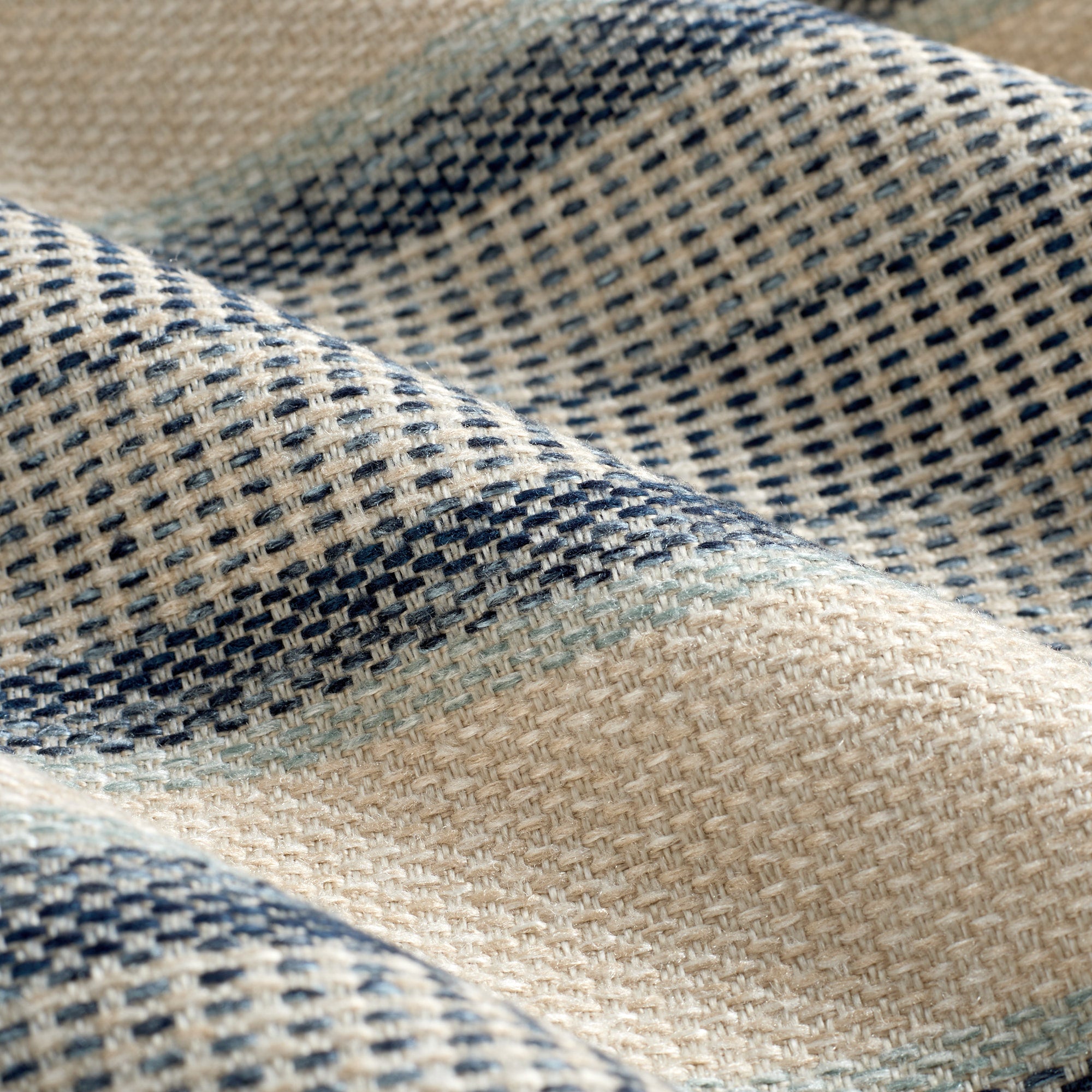 Close up of Tonic Living Miller Stripe Denim fabric showing faded denim, pale blue, and sandy beige stripes with woven texture.