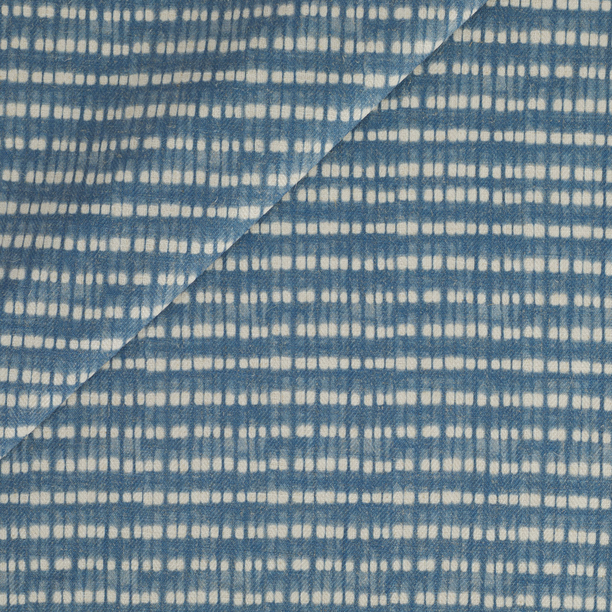 Tonic Living Nile Fabric in Indigo featuring a blue and white dotted stripe with a shibori-inspired look.