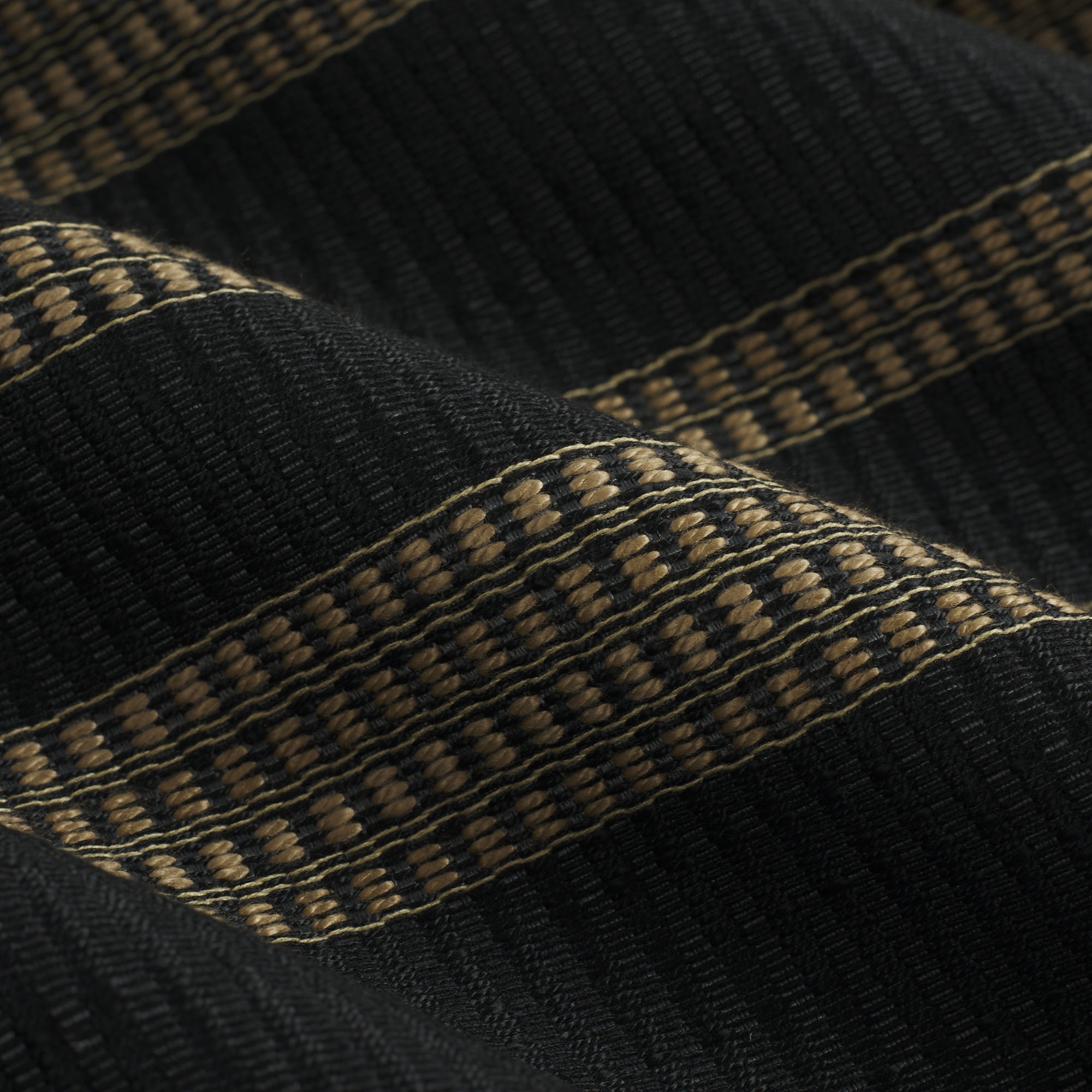 Close up of Tonic Living Odessa InsideOut Carbon fabric showing its black and tan vertical stripe detail.