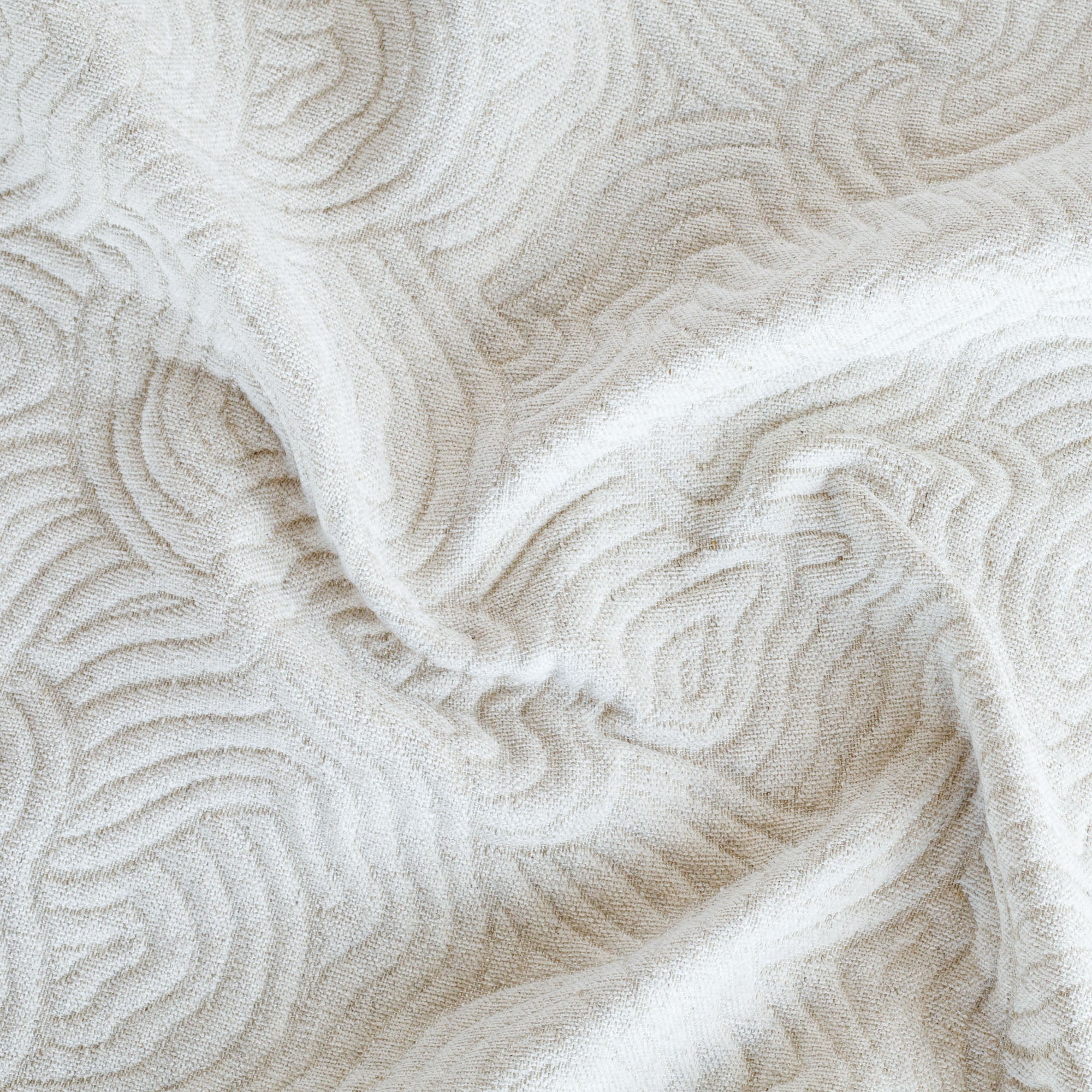 a soft cream quilted abstract floral patterned upholstery fabric