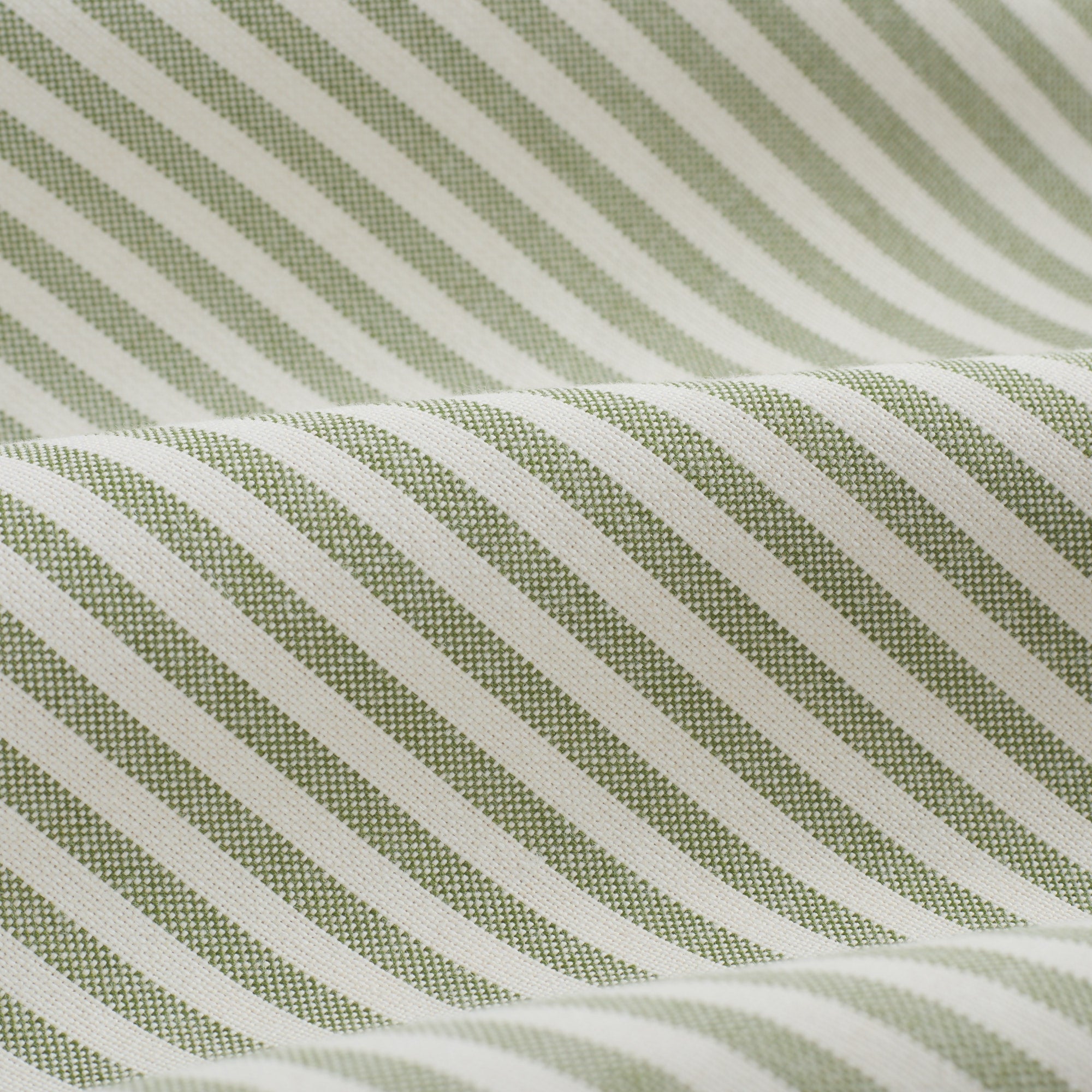 Close up of Tonic Living Refresh Sunbrella Hedge fabric showing green and white ticking stripe detail.
