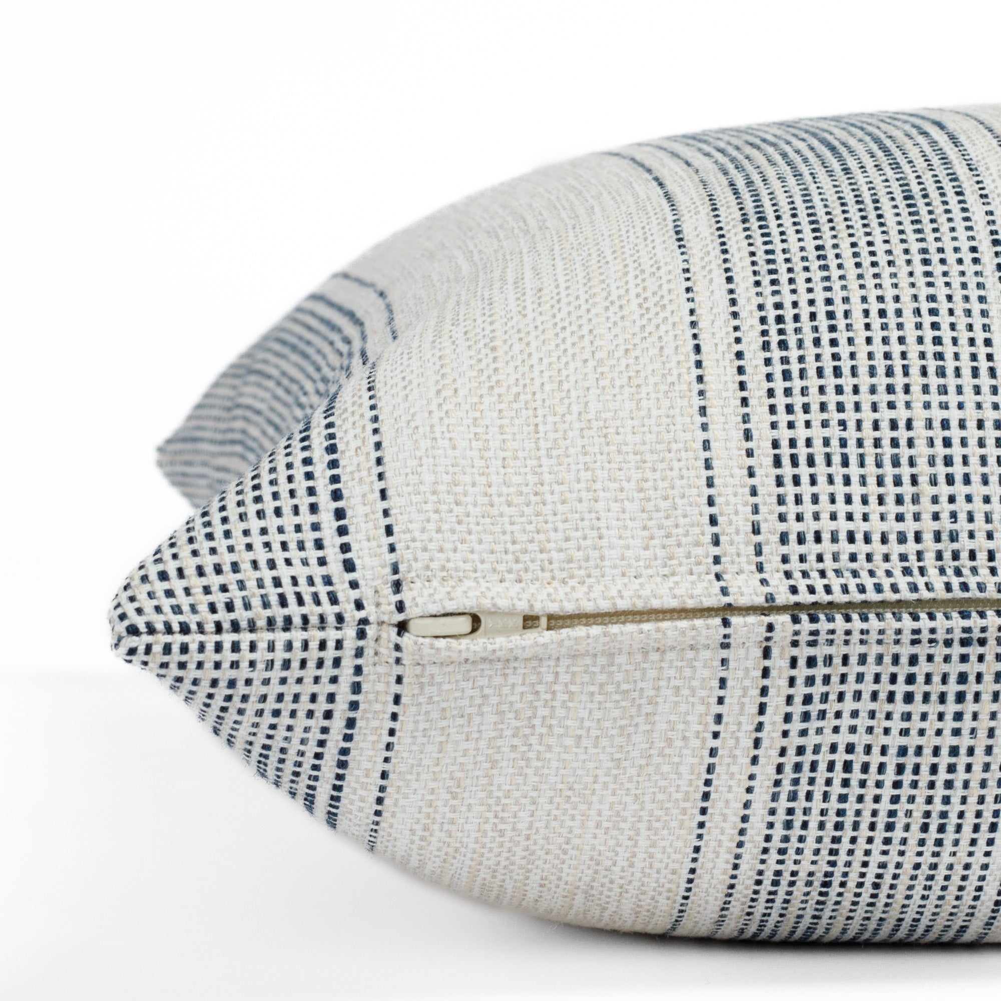 Revitalize denim blue & beige pillow, a striped indoor/outdoor pillow from Tonic Living: close up zipper view.