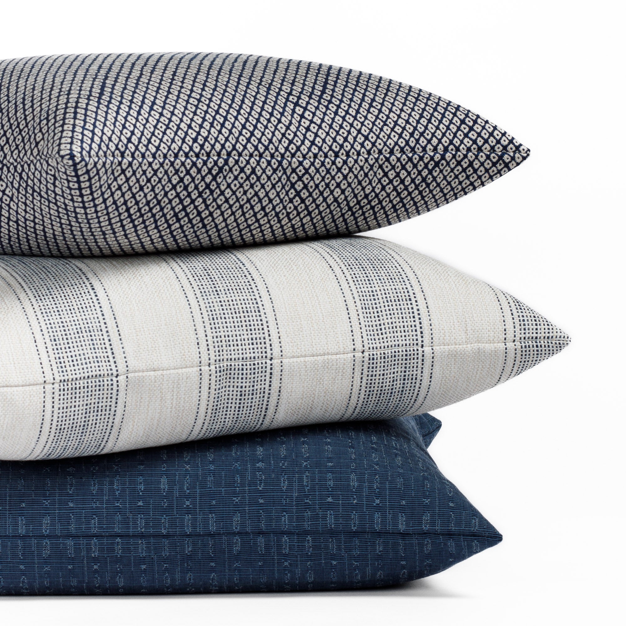 A selection of navy blue and white patterned indoor/outdoor pillows from Tonic Living.