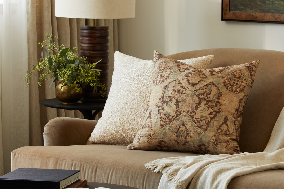 Tonic Living Rupert Parchment cream bouclé pillow styled on a sofa with Zuri Driftwood medallion throw pillow.